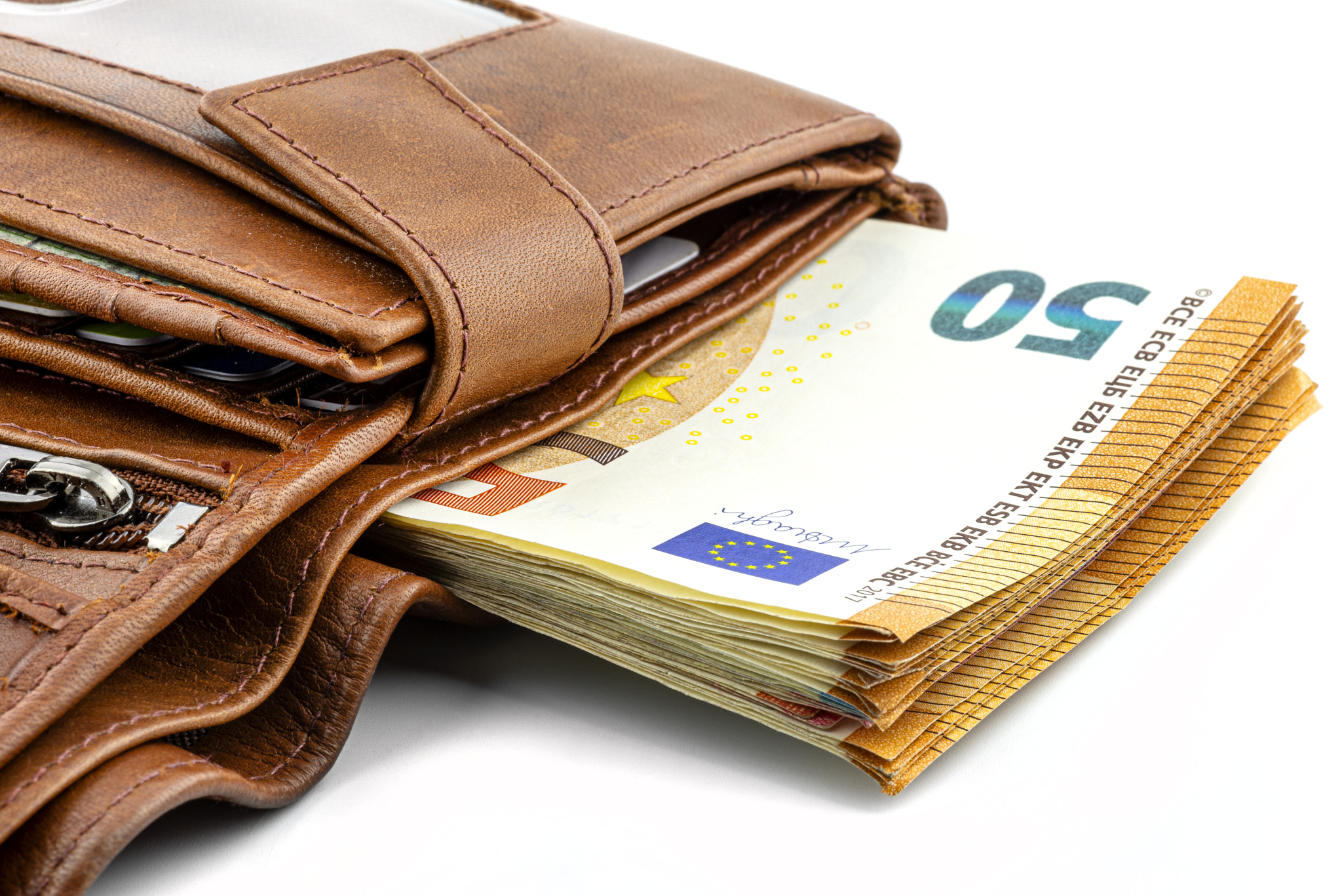 A macro shot of a brown mens leather wallet with a stack of Euro notes