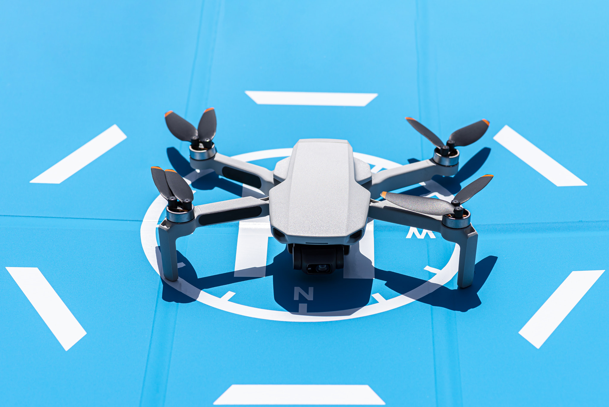 The drone is standing on a blue landing field.