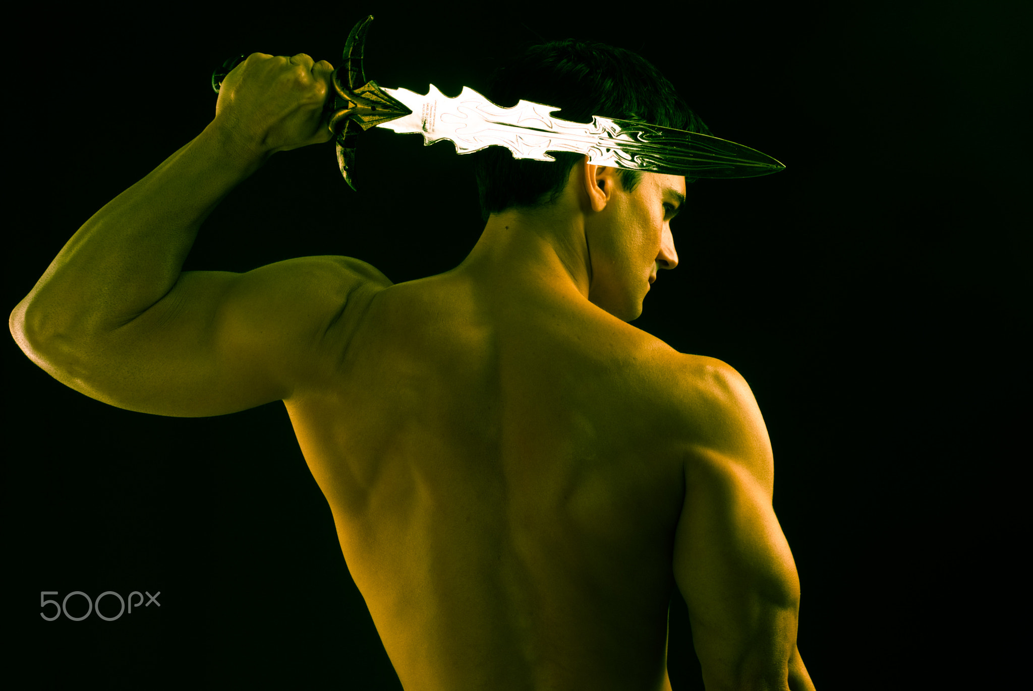 The sexy man holds a sword.