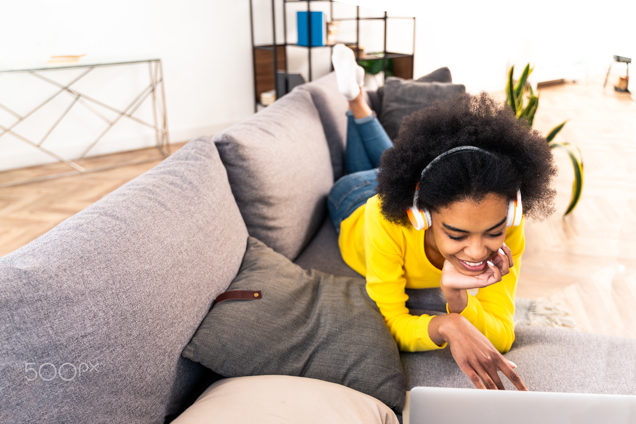 Afro american woman at home listening music with headphones