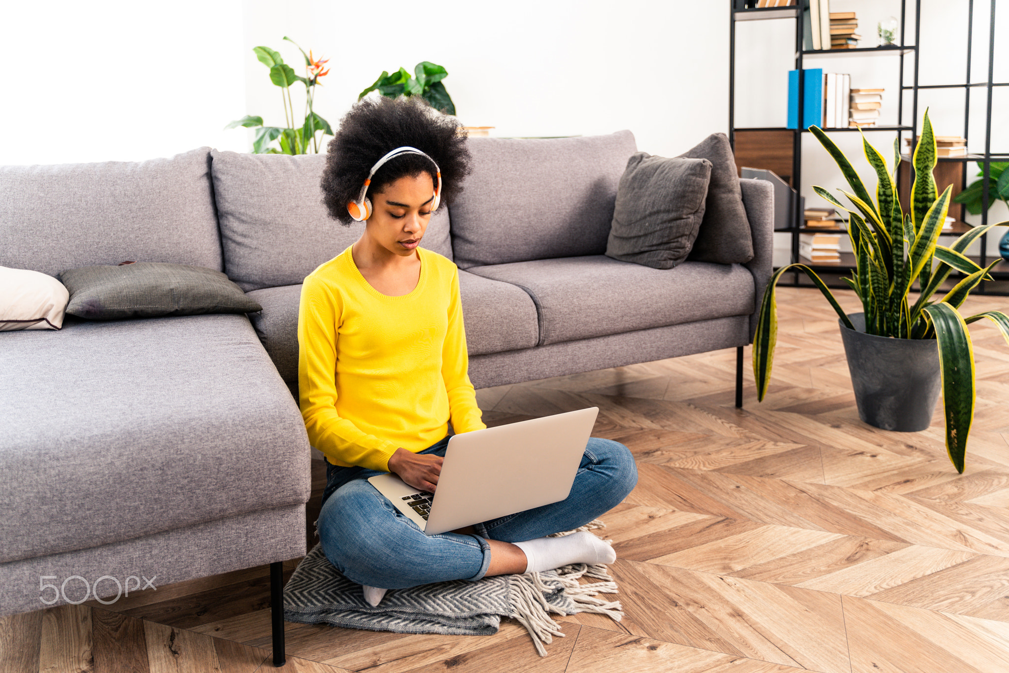 Afro american woman at home listening music with headphones