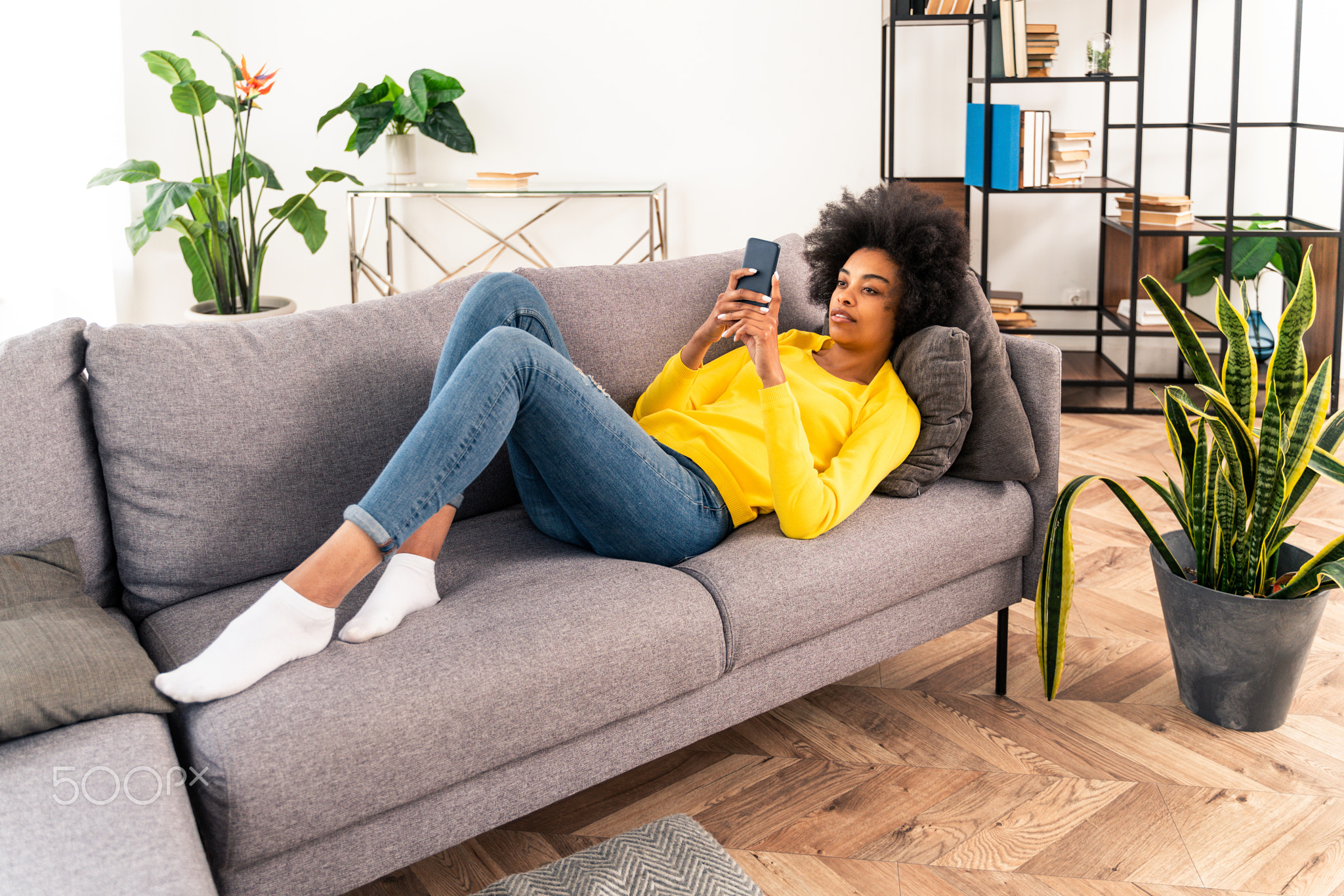 Afro american woman at home holding her smartphone