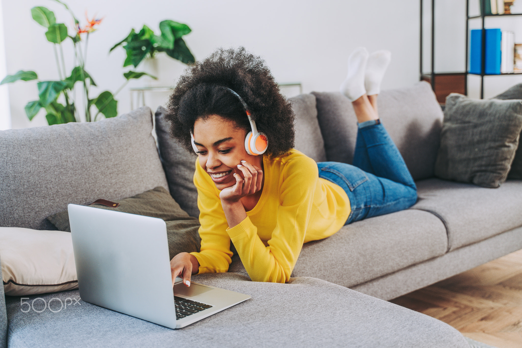 Afro american woman at home listening music with headphones