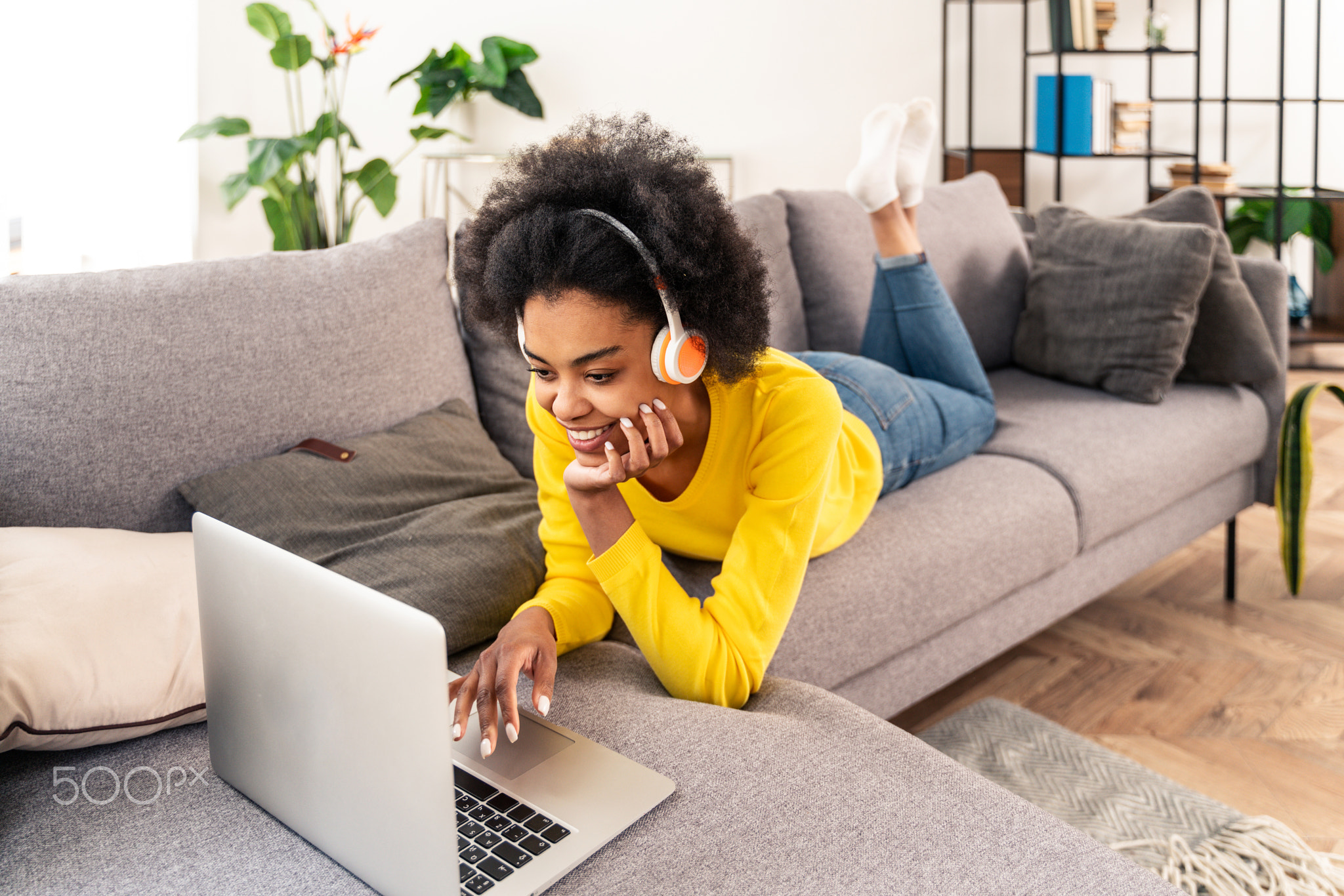 Afro american woman at home listening music with headphones