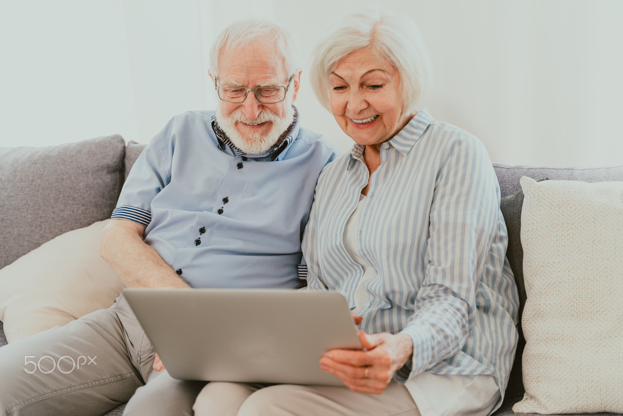 Elderly couple with computer laptop at home