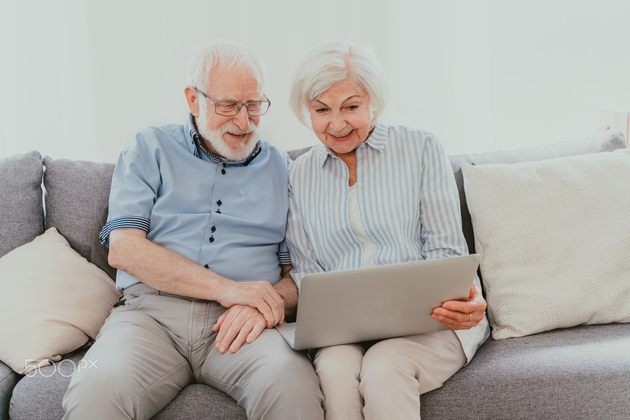 Elderly couple with computer laptop at home