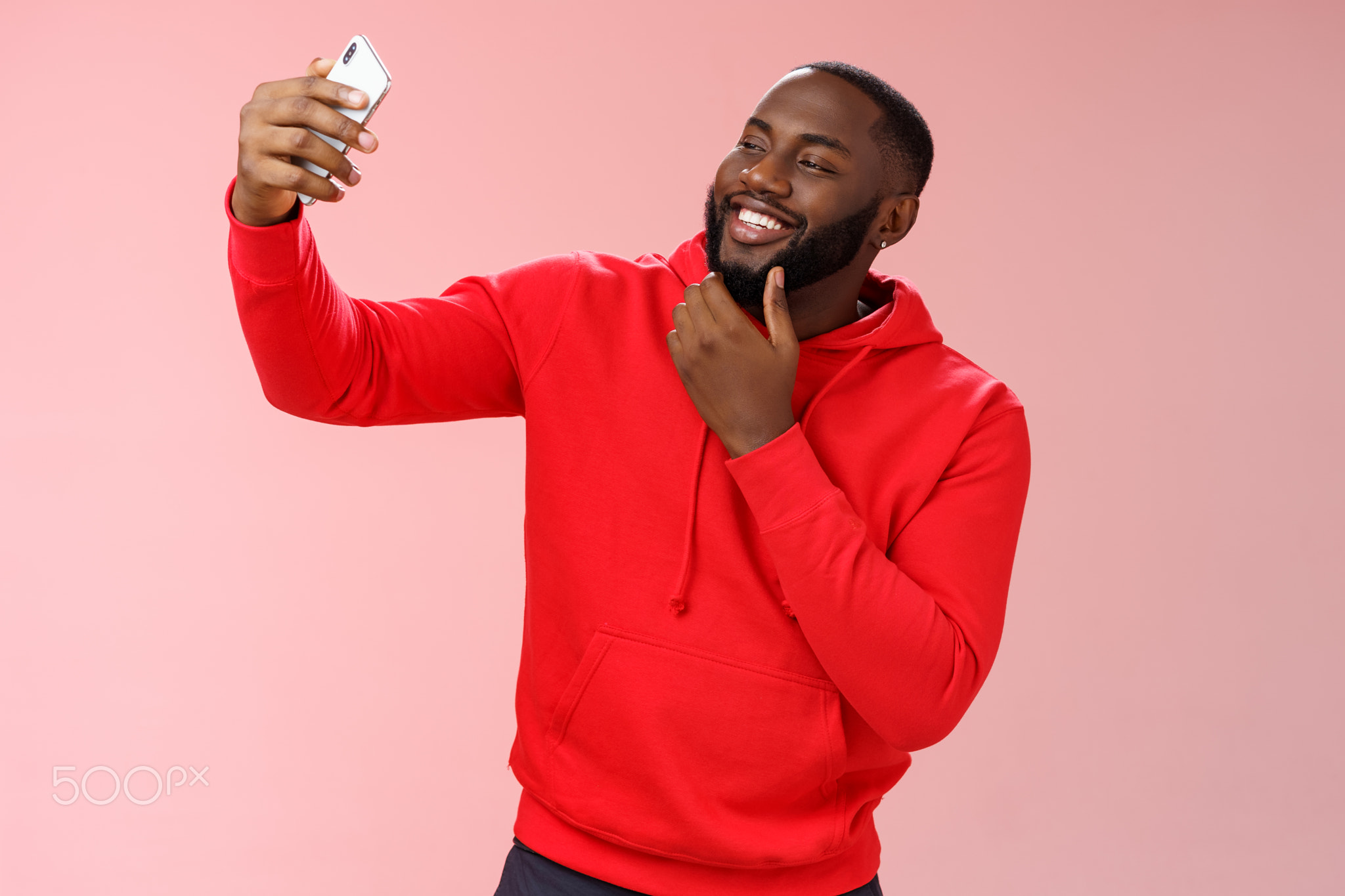 Cheeky cool african american confident bearded guy in red hoodie