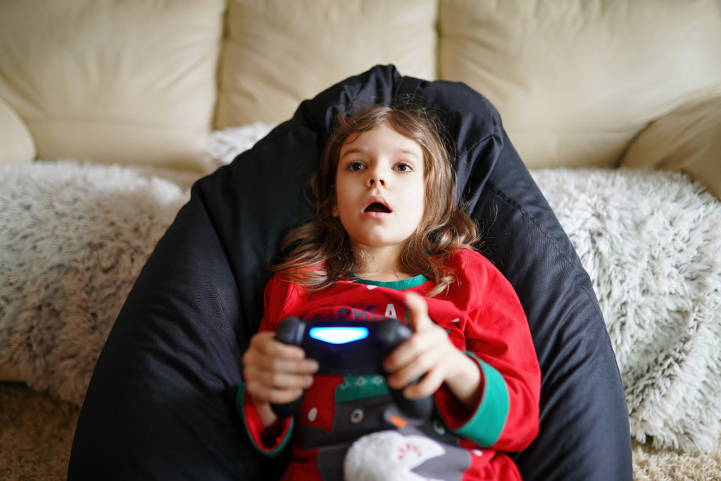 Gamer girl playing gamepad, joystick in games on big screen by Aleksandr Zamuruev on 500px.com