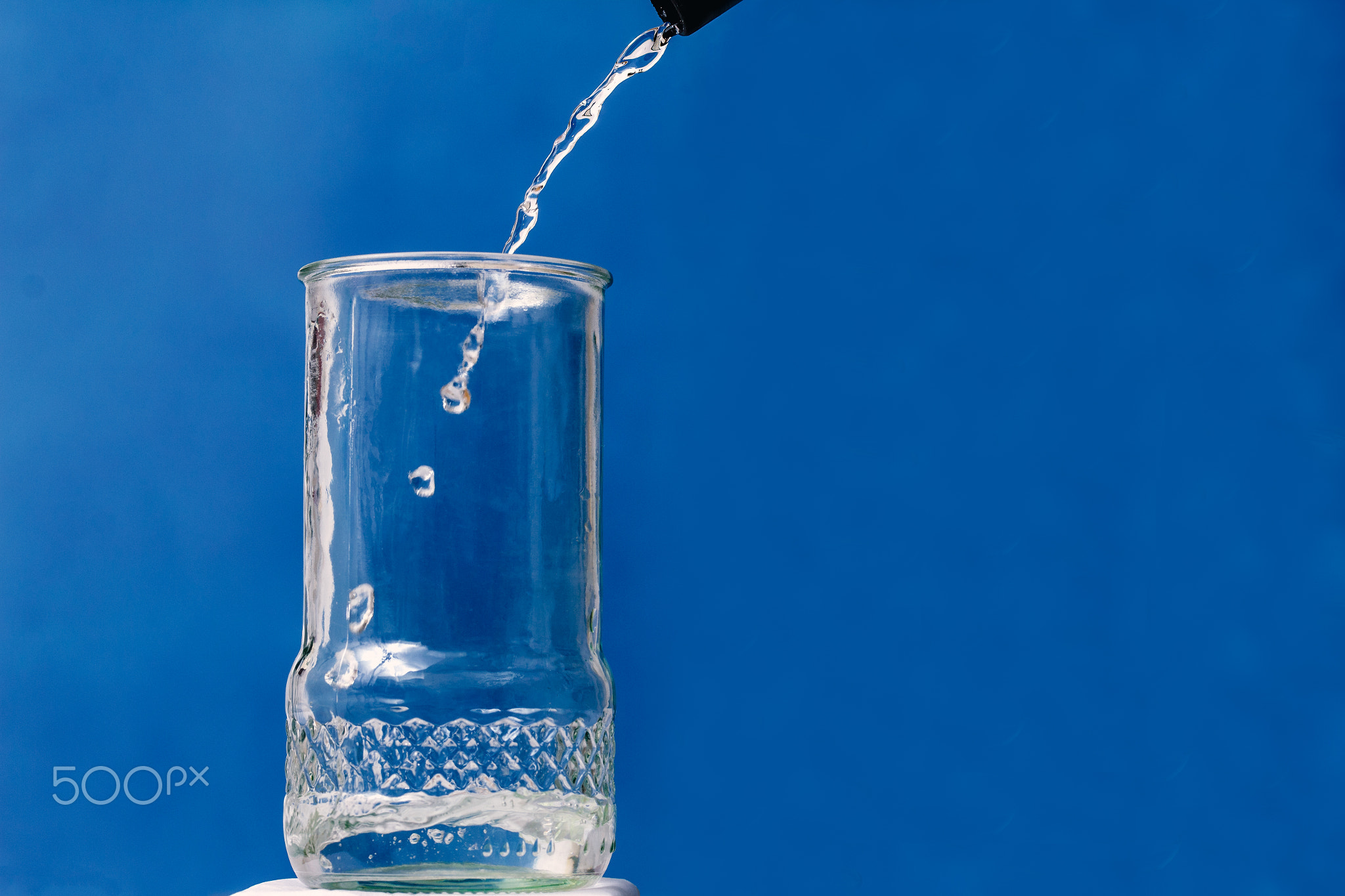 Distilled water flowing into a glass container