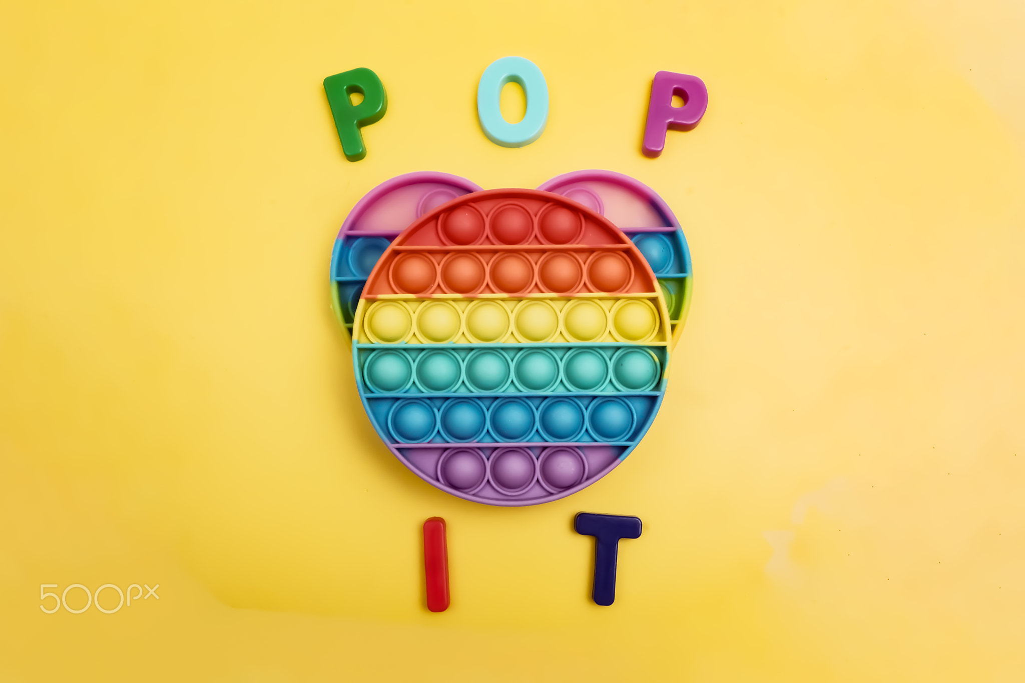 the pop it toy lies on a yellow background, the inscription pop it