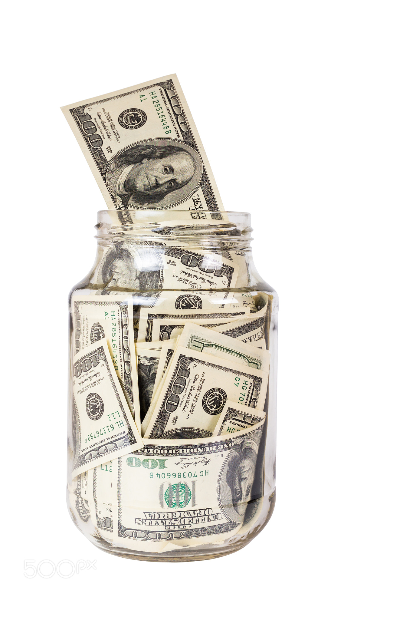 A hundred US dollars bank notes in a glass jar isolated on white