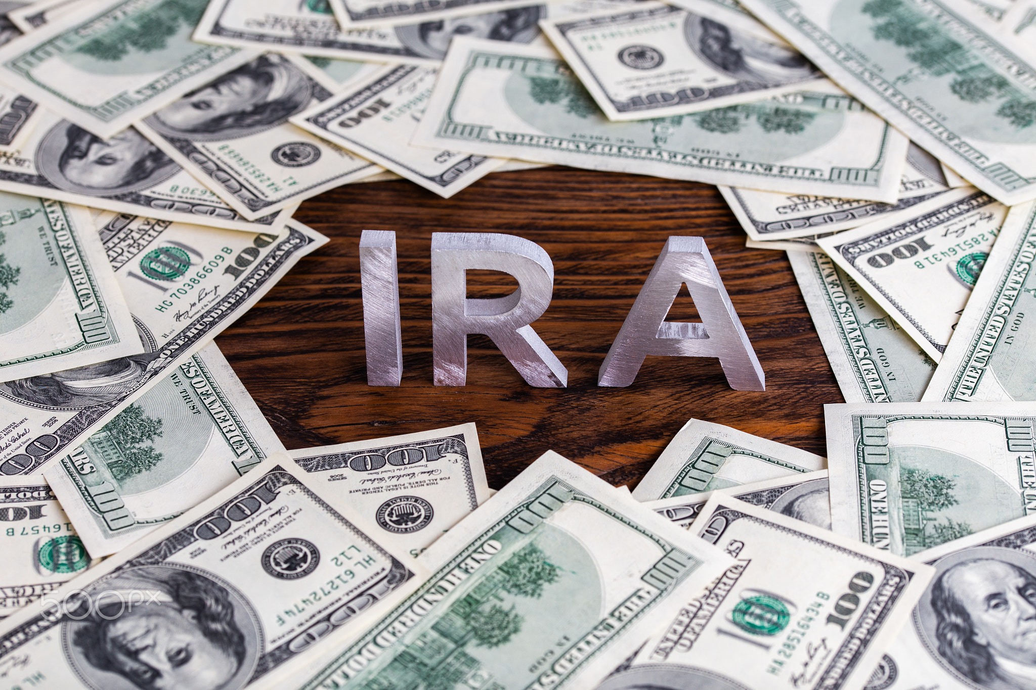 the word ira made of silver metal letters on wooden background