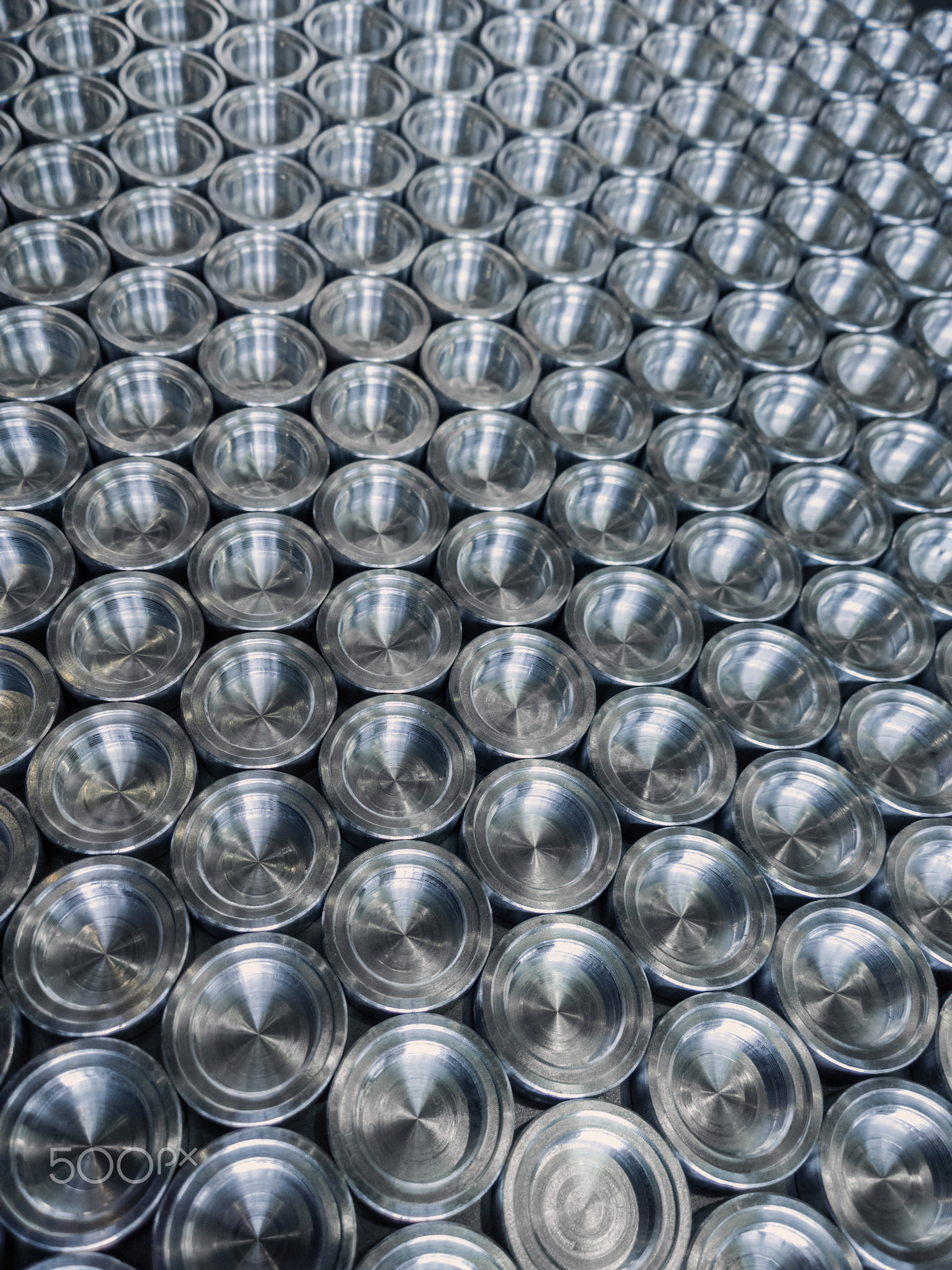 Shiny metal parts after cnc turning, on flat surface selective focus