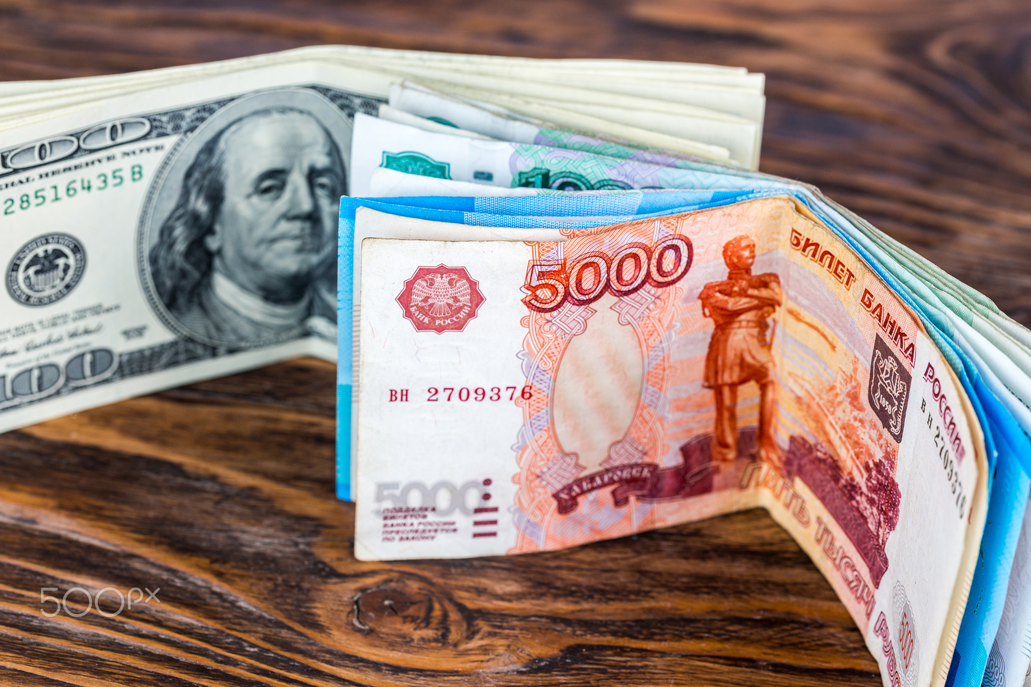 a two bunches of russian rubl and us dollar banknotes standing on