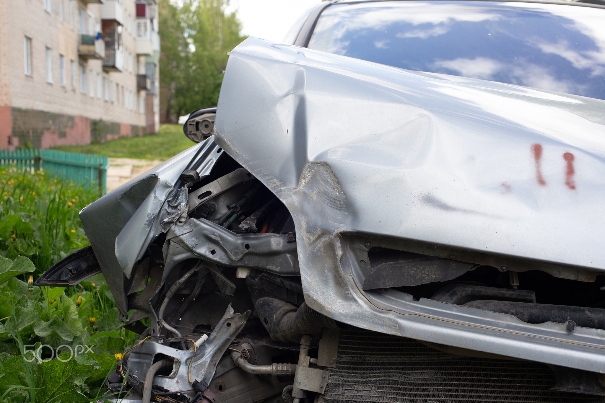close-up view on silver car physically damaged in road accident, close