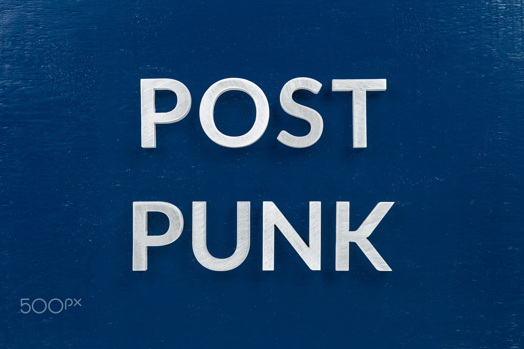 words post punk laid with aluminium letters over blue painted board