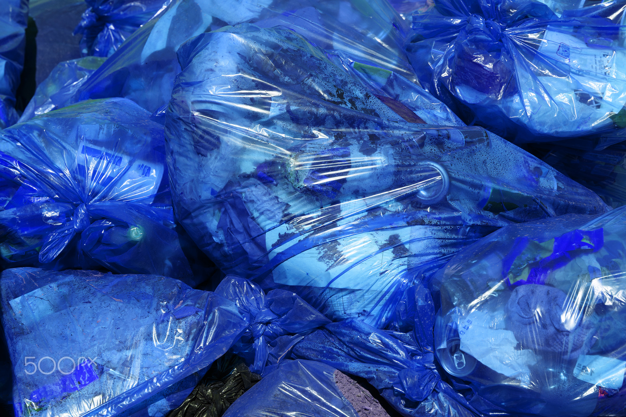 full frame background of blue plastic trash bags with generic domestic