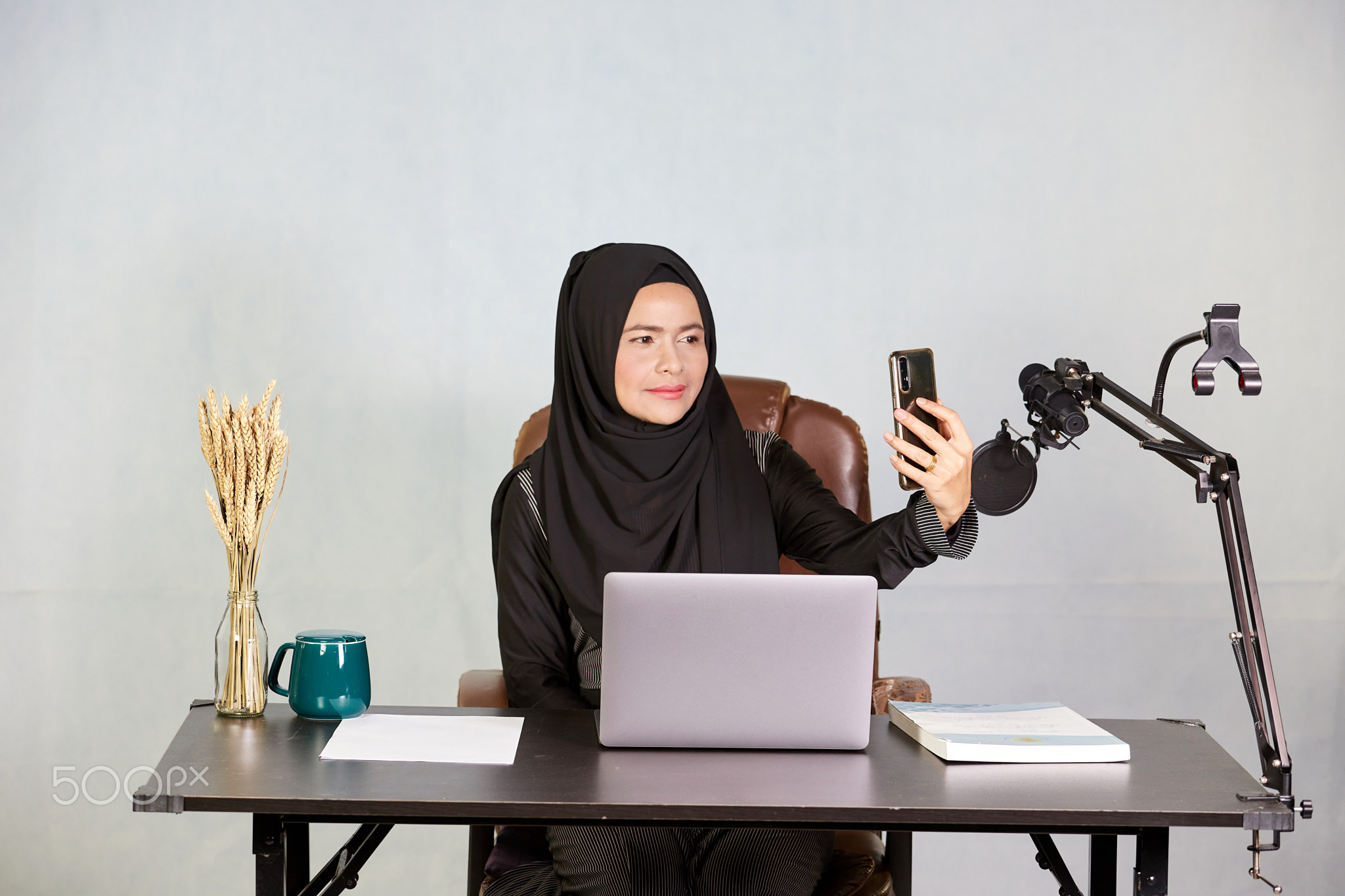 Asian Muslim business woman takes selfie by mobile