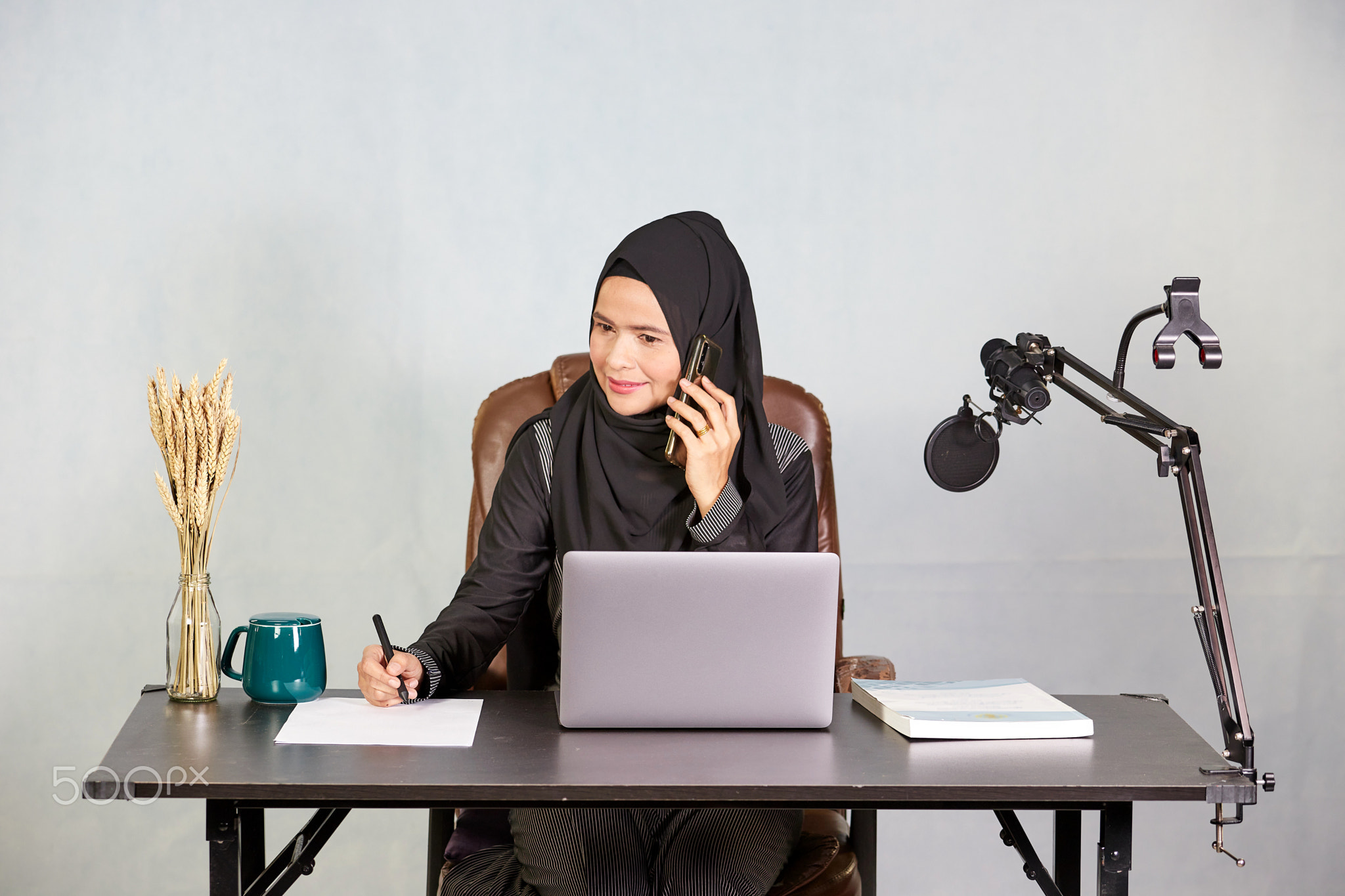 Asian muslim business woman using mobile phone during working