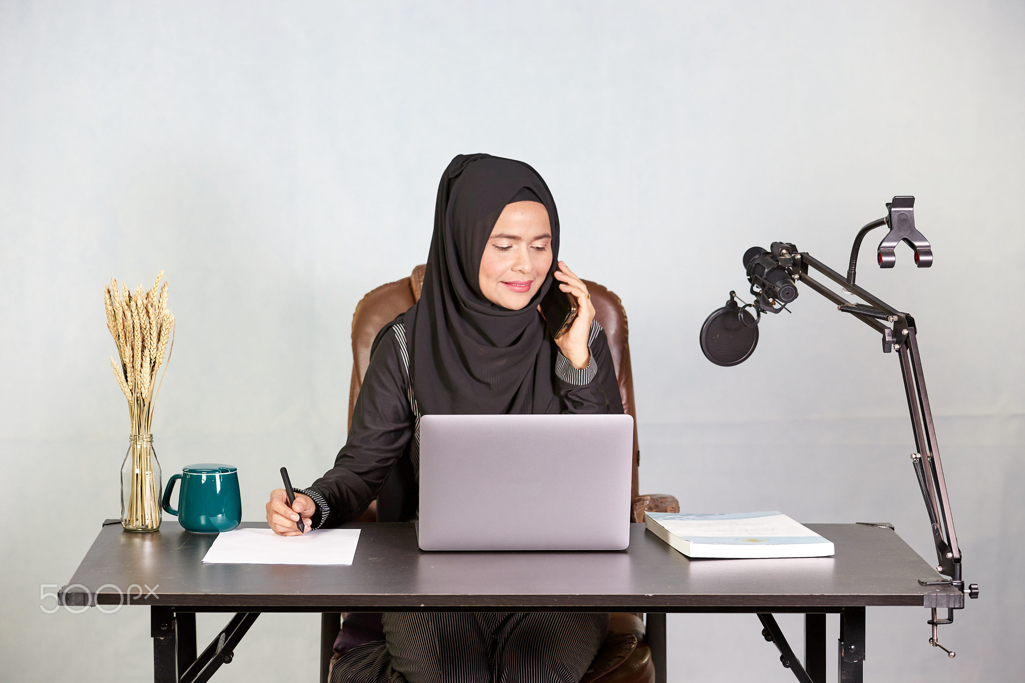 Asian muslim business woman using mobile phone during working