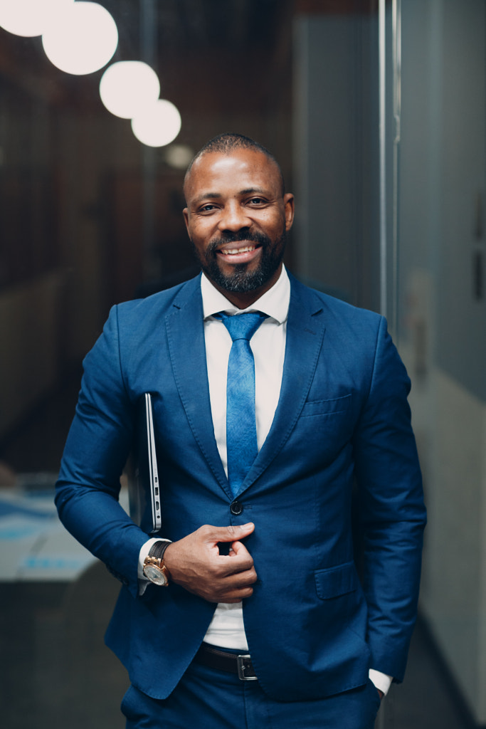 Portrait smiling african american businessman in blue suit in office by Max Chernishev on 500px.com