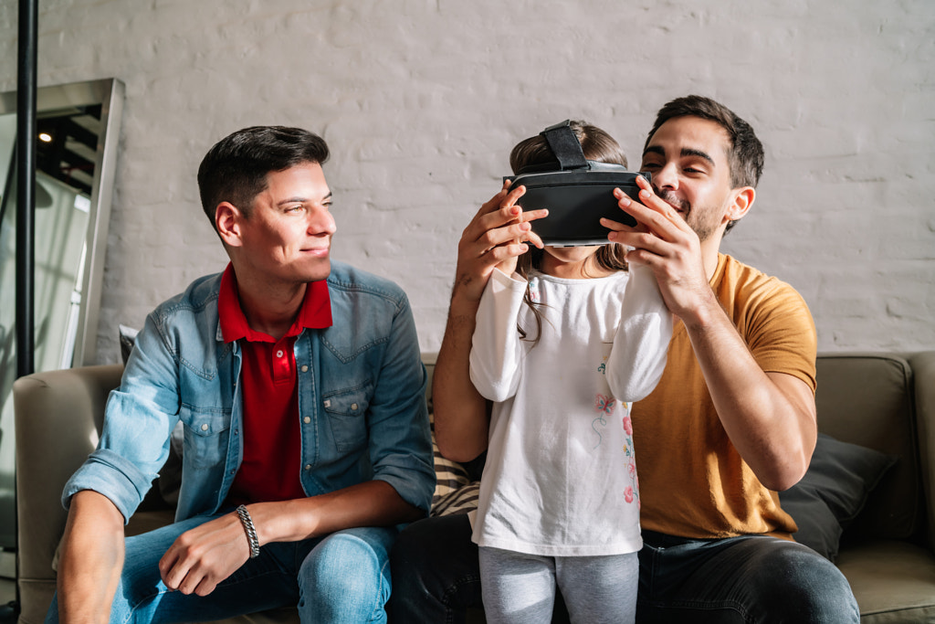 Little girl playing video games with her parents at home. by Mego Studio on 500px.com