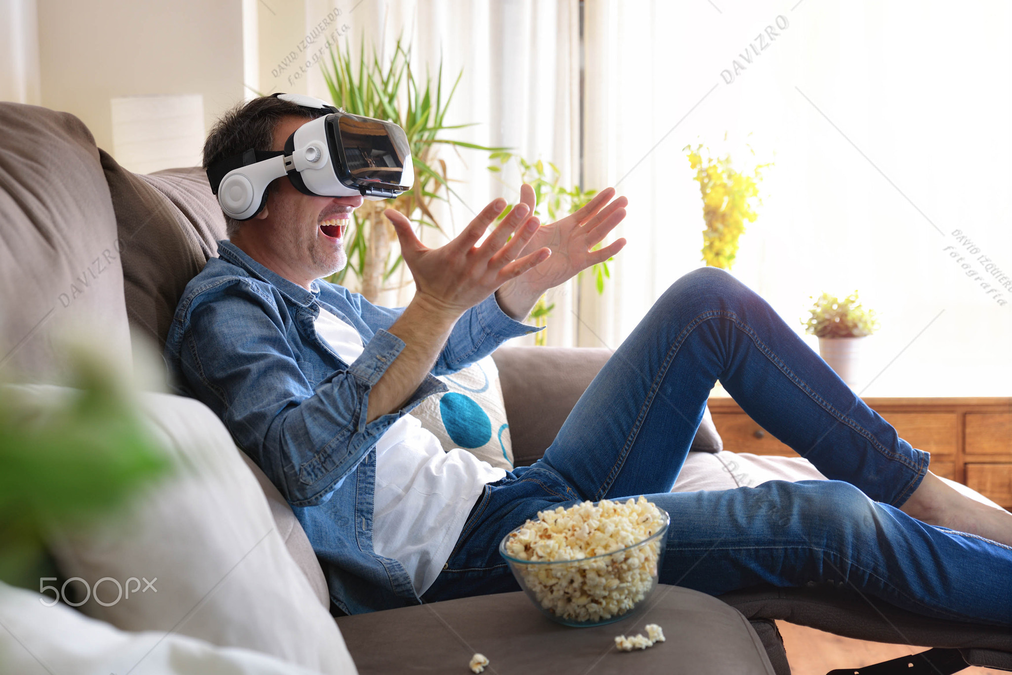 Man enjoying watching movies in vr glasses on the couch