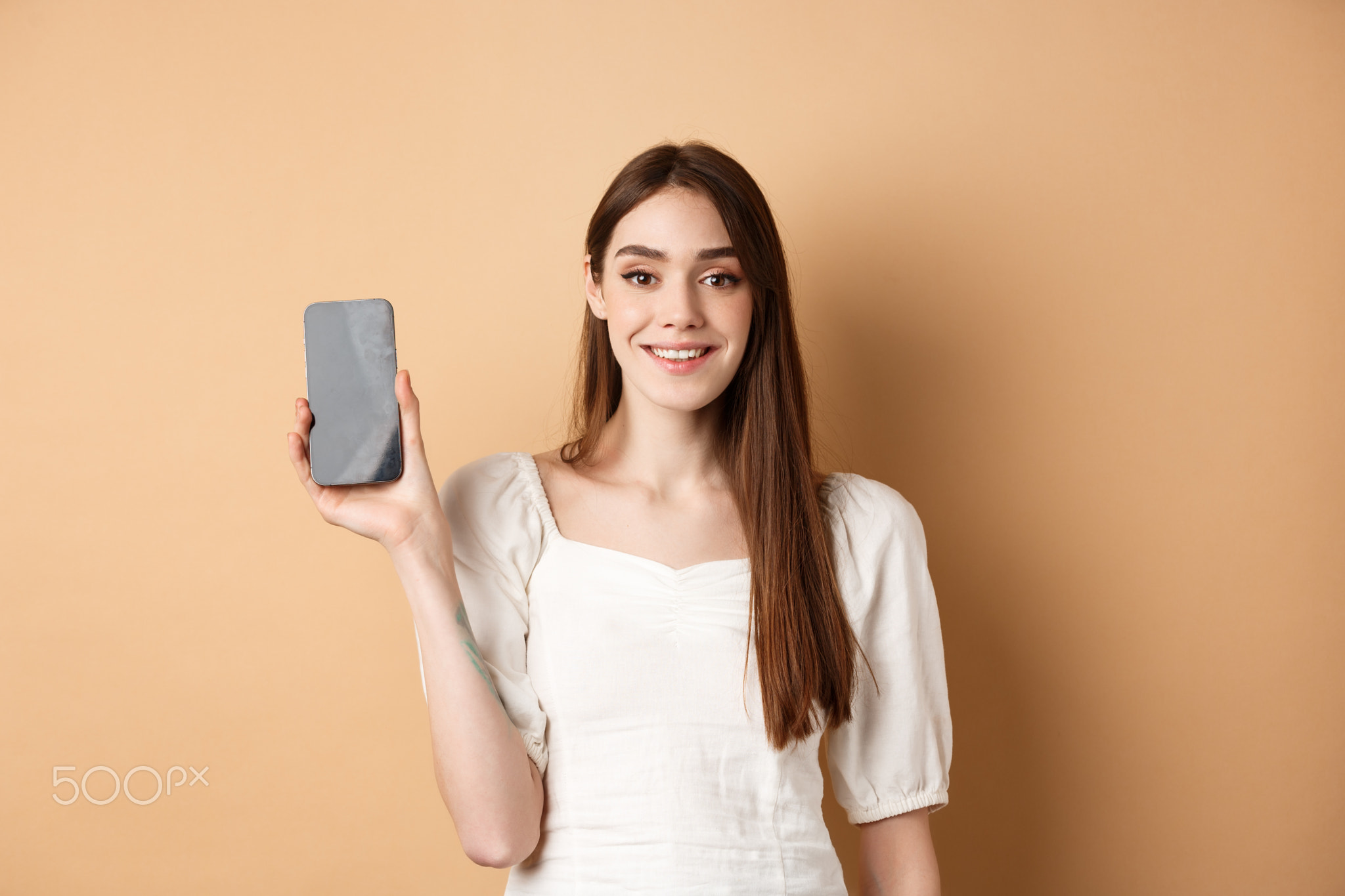 Happy girl showing empty mobile screen and smiling, demonstrate phone