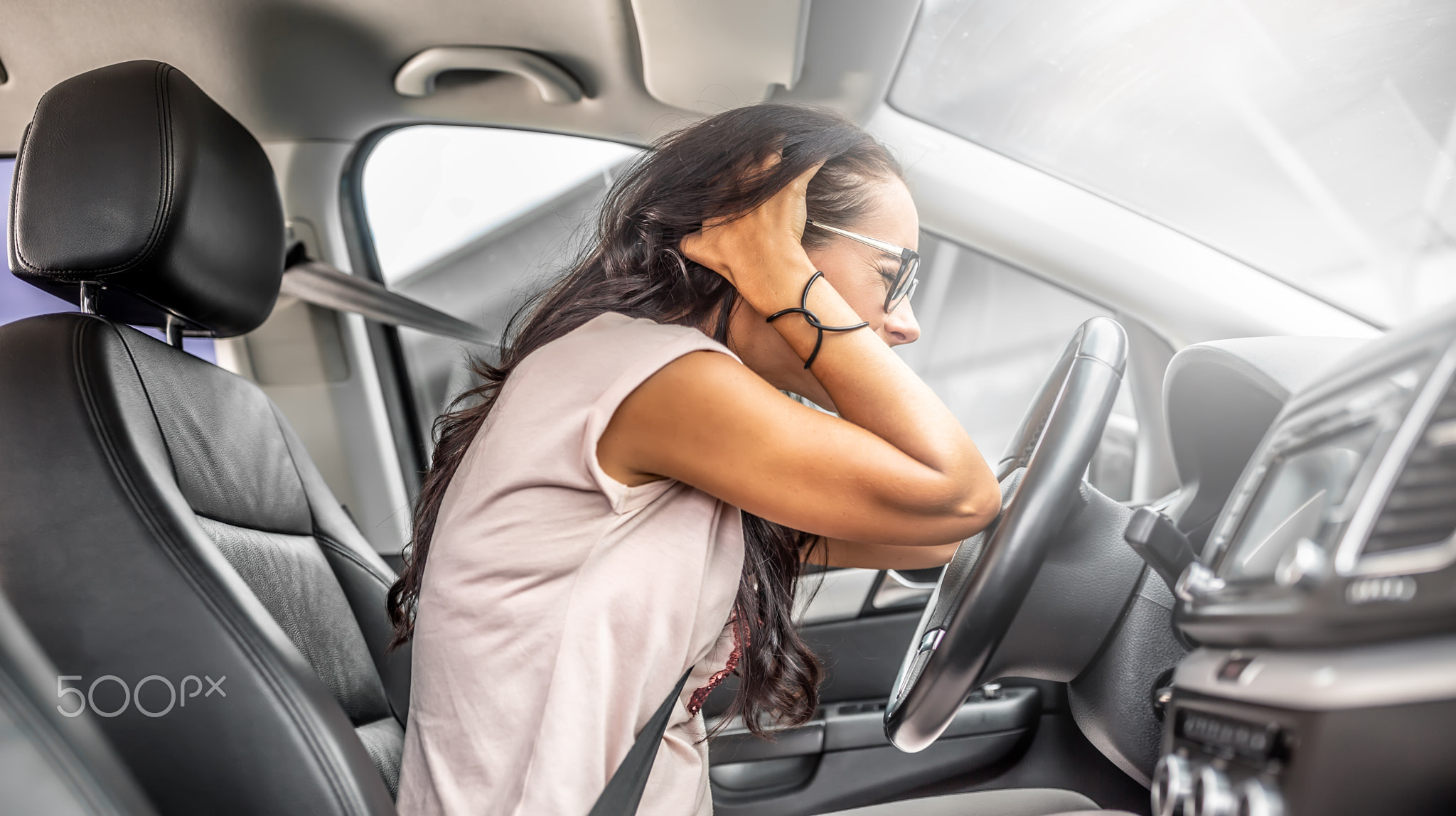 Female driver with headache or in desperation holds her head with