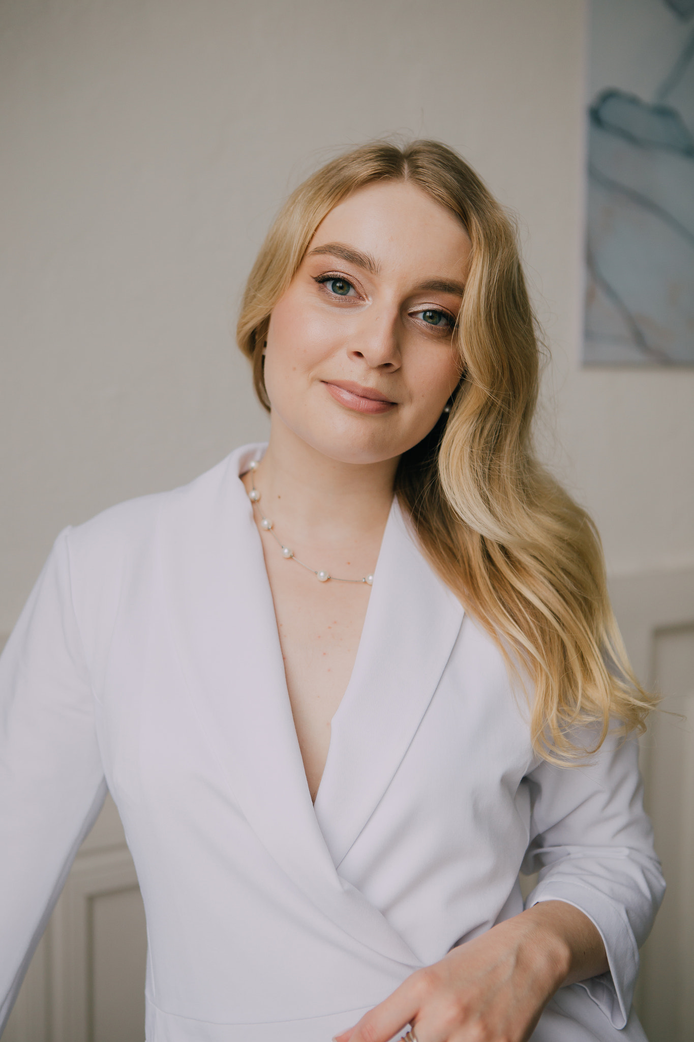 female doctor in a white medical coat stands against of a white wall