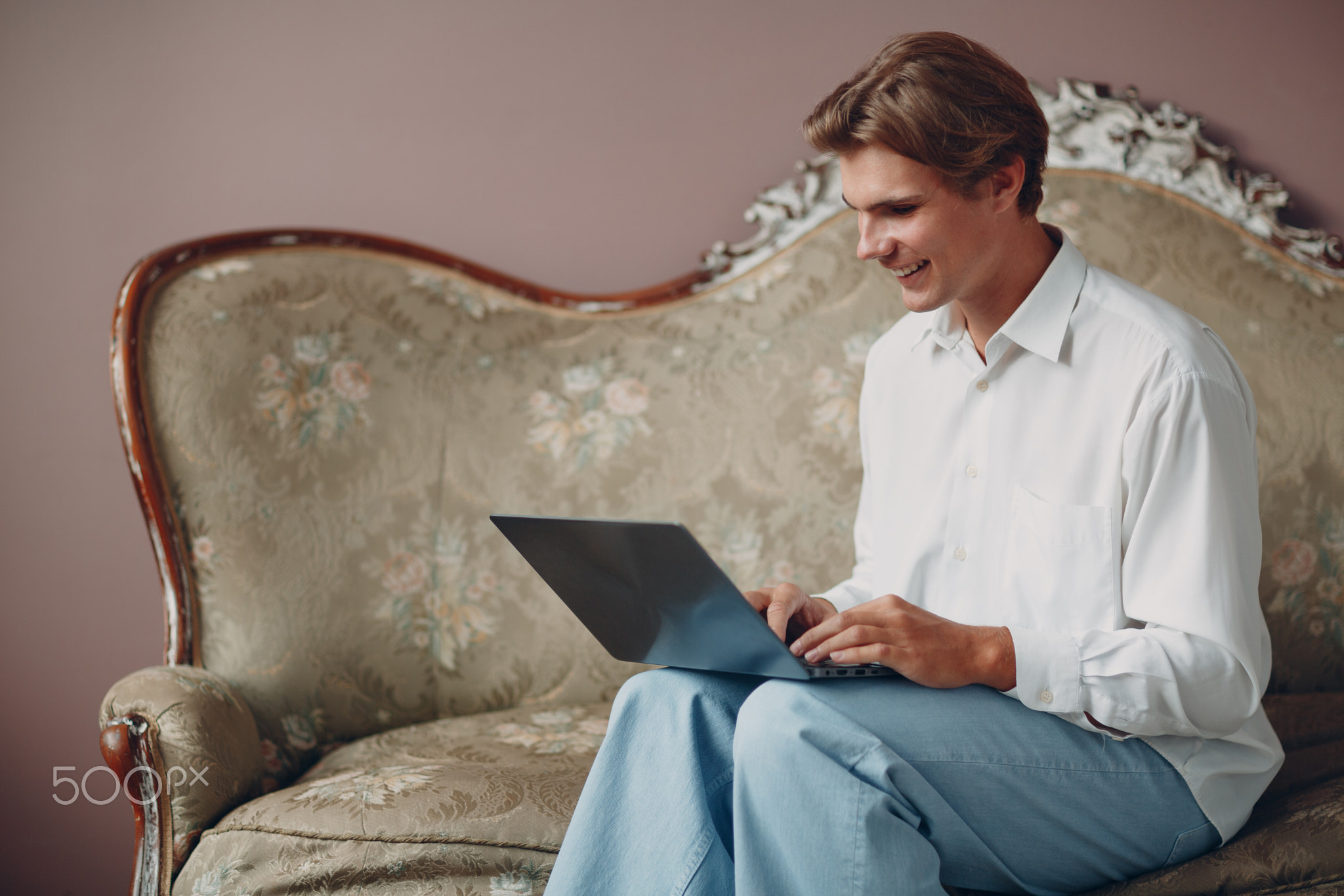 Portrait young man sitting with laptop at studio.