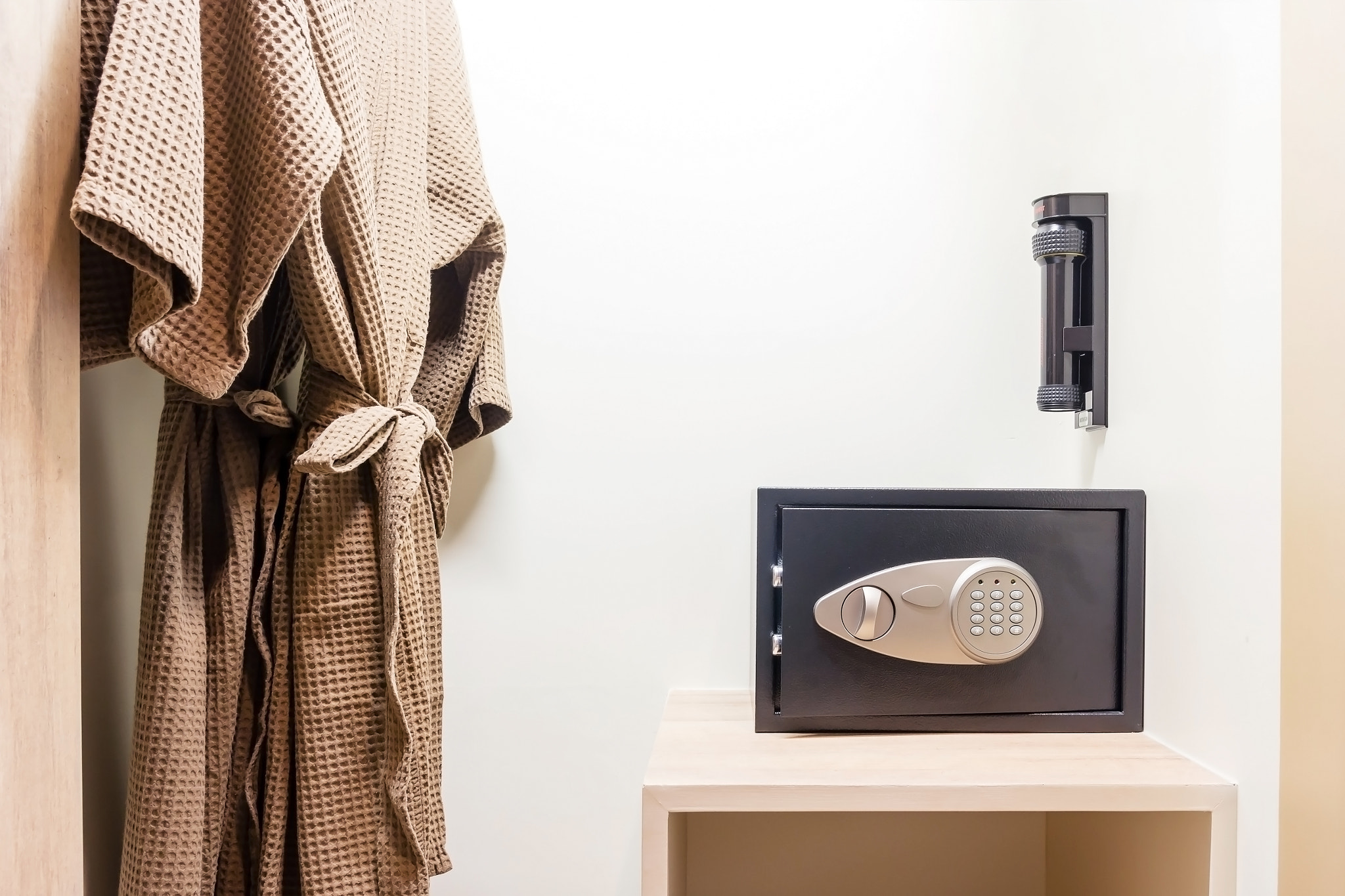 Safe box with electronic lock hidden in the wardrobe at the hotel.