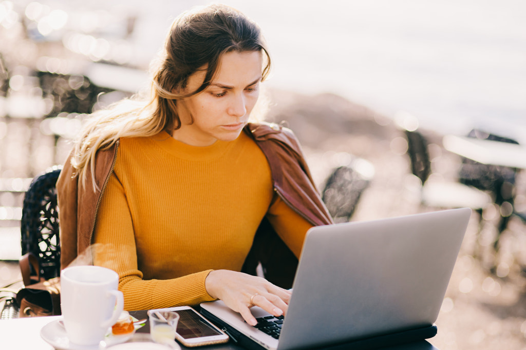 Ciddi Kadın girişimci, 500px.com'da Avanti tarafından kafede açık havada dizüstü bilgisayarda çalışıyor