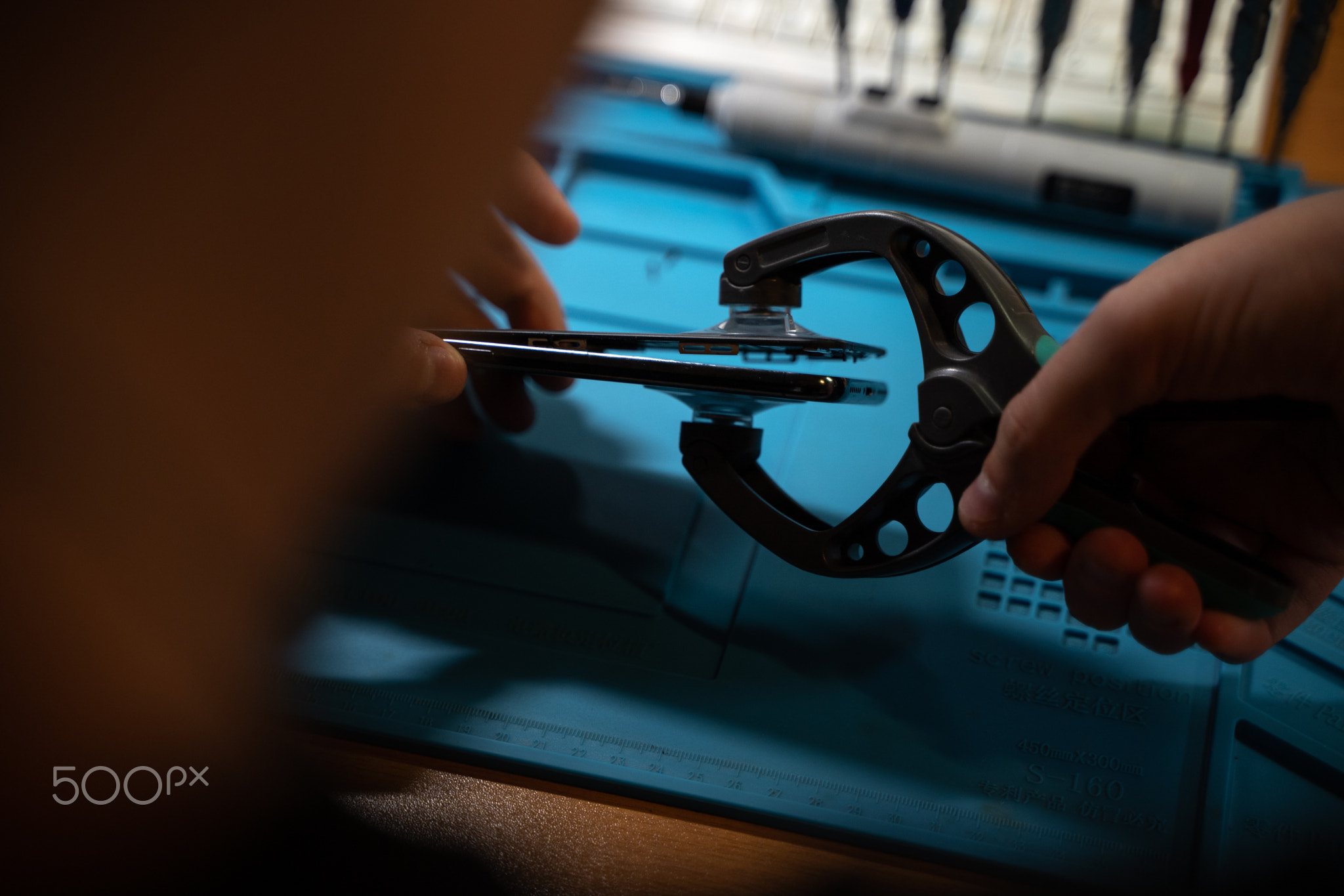 Hand technician open the smartphone to repair with a suction cup