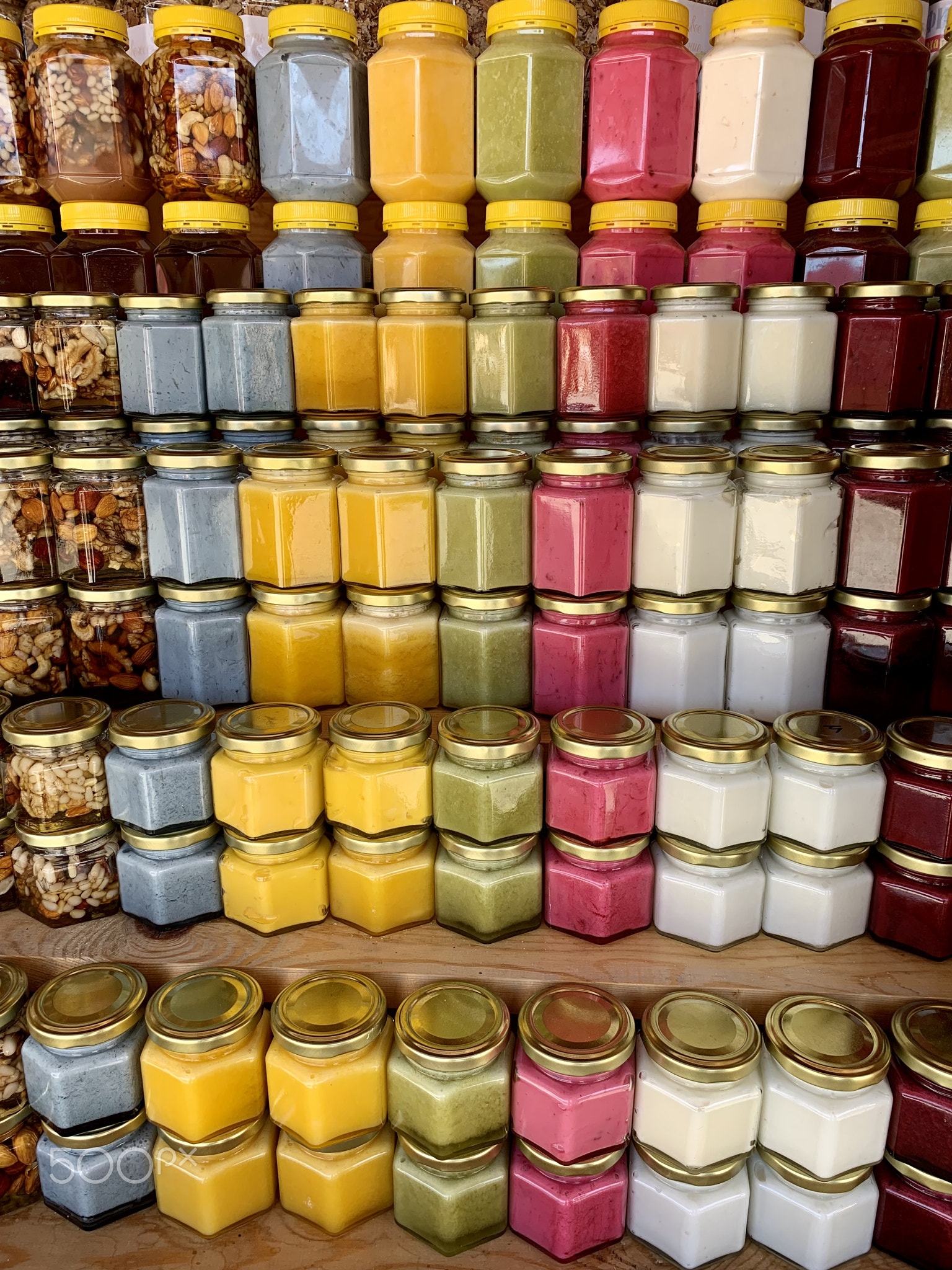 There are many jars of organic, natural honey on the counter for sale