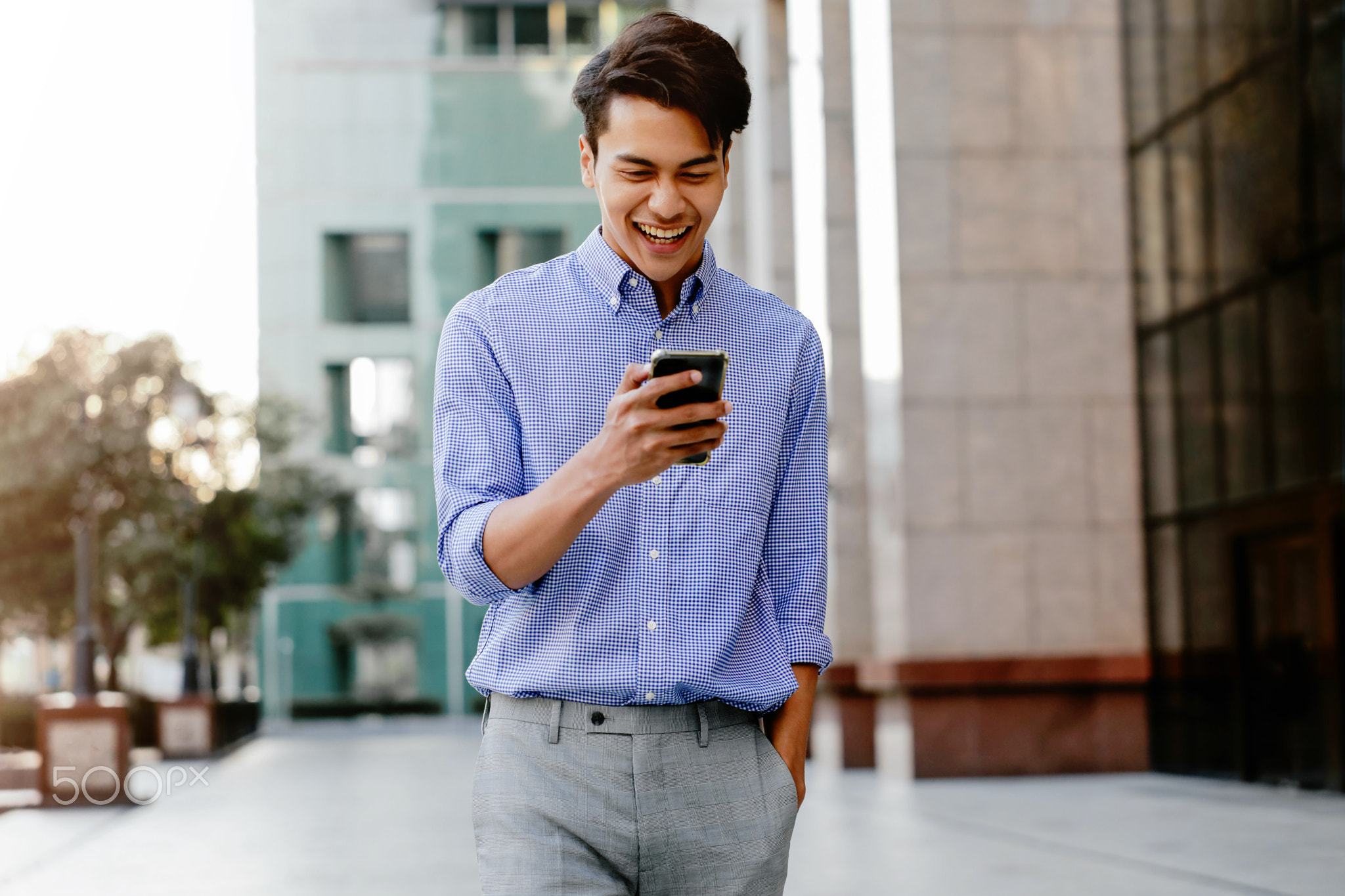 Portrait of a Happy Young Businessman Using Mobile Phone