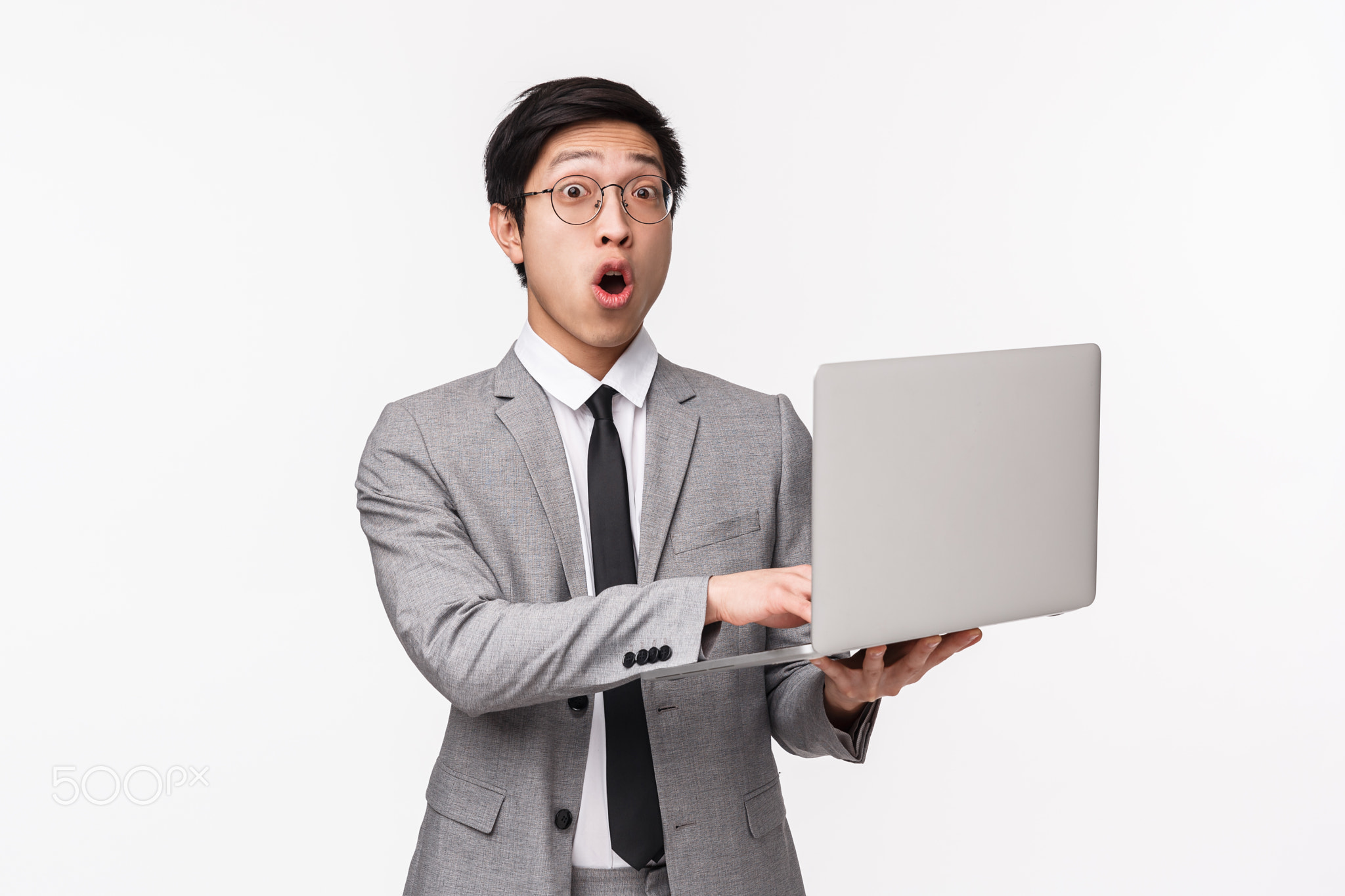 Waist-up portrait of amazed and fascinated young asian male office