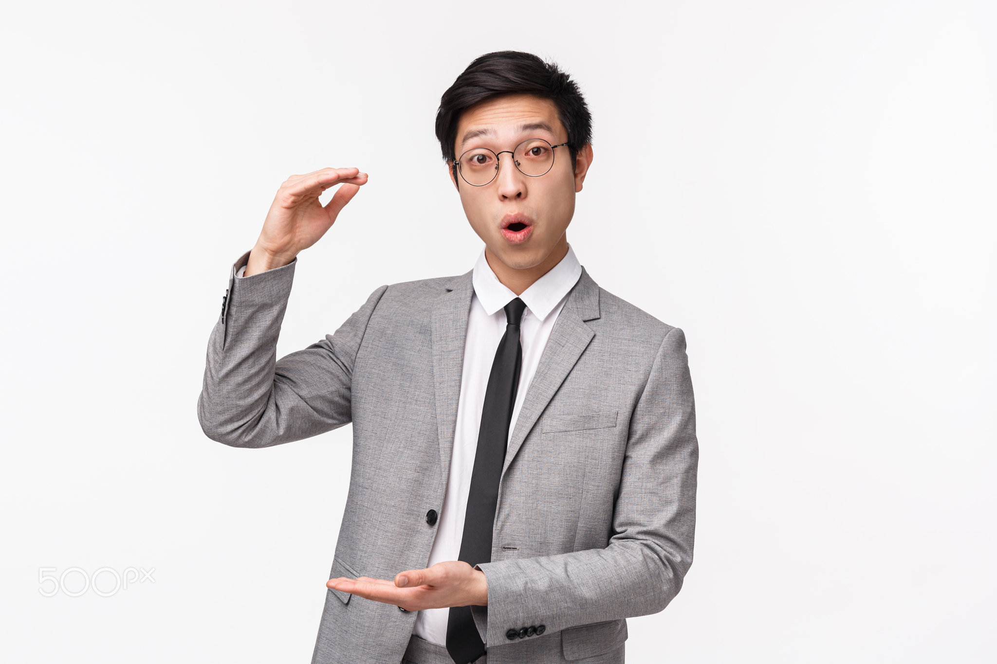 Waist-up portrait of excited and impressed young asian male office