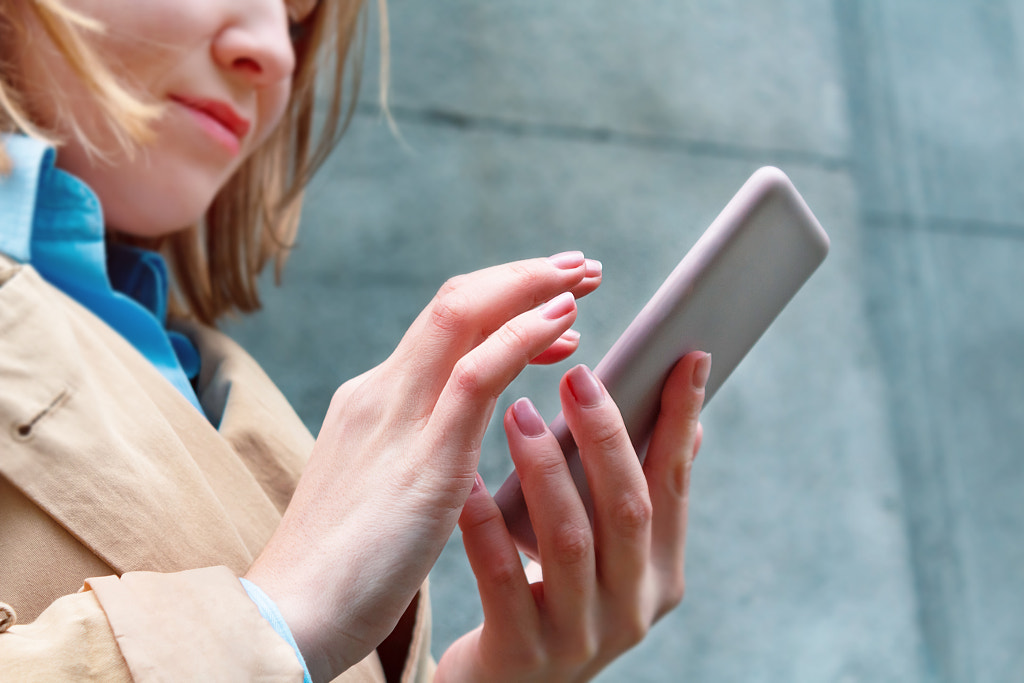 Woman holding mobile phone in hand. by Anna Derzhina on 500px.com