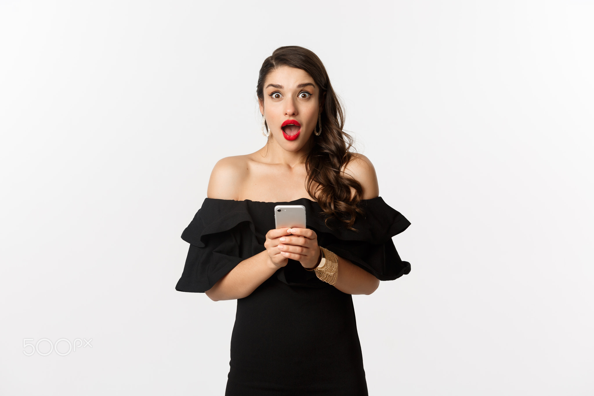 Happy young glamour woman in black dress, holding mobile phone and