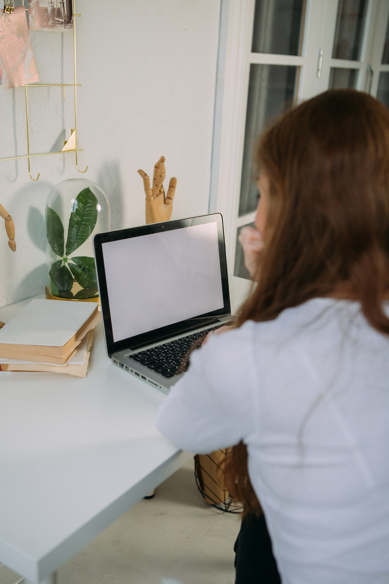 young girl working at home at the table on a laptop