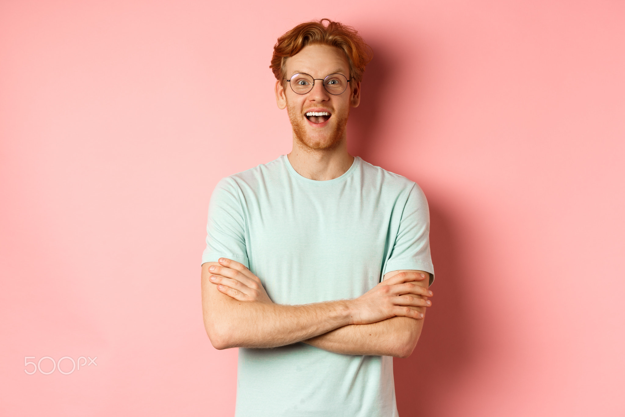 Portrait of cheerful european man in glasses looking amazed at camera