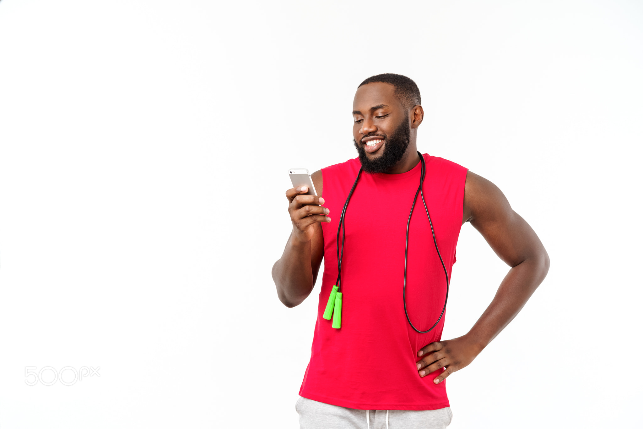 Mature fit African American man texting on mobile and holding elastic