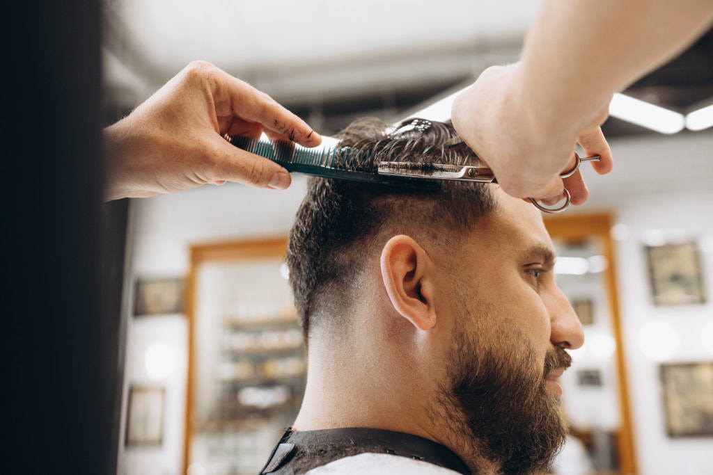 Man getting haircut at the barbershop. Professional barber at work by Volodymyr Melnyk on 500px.com