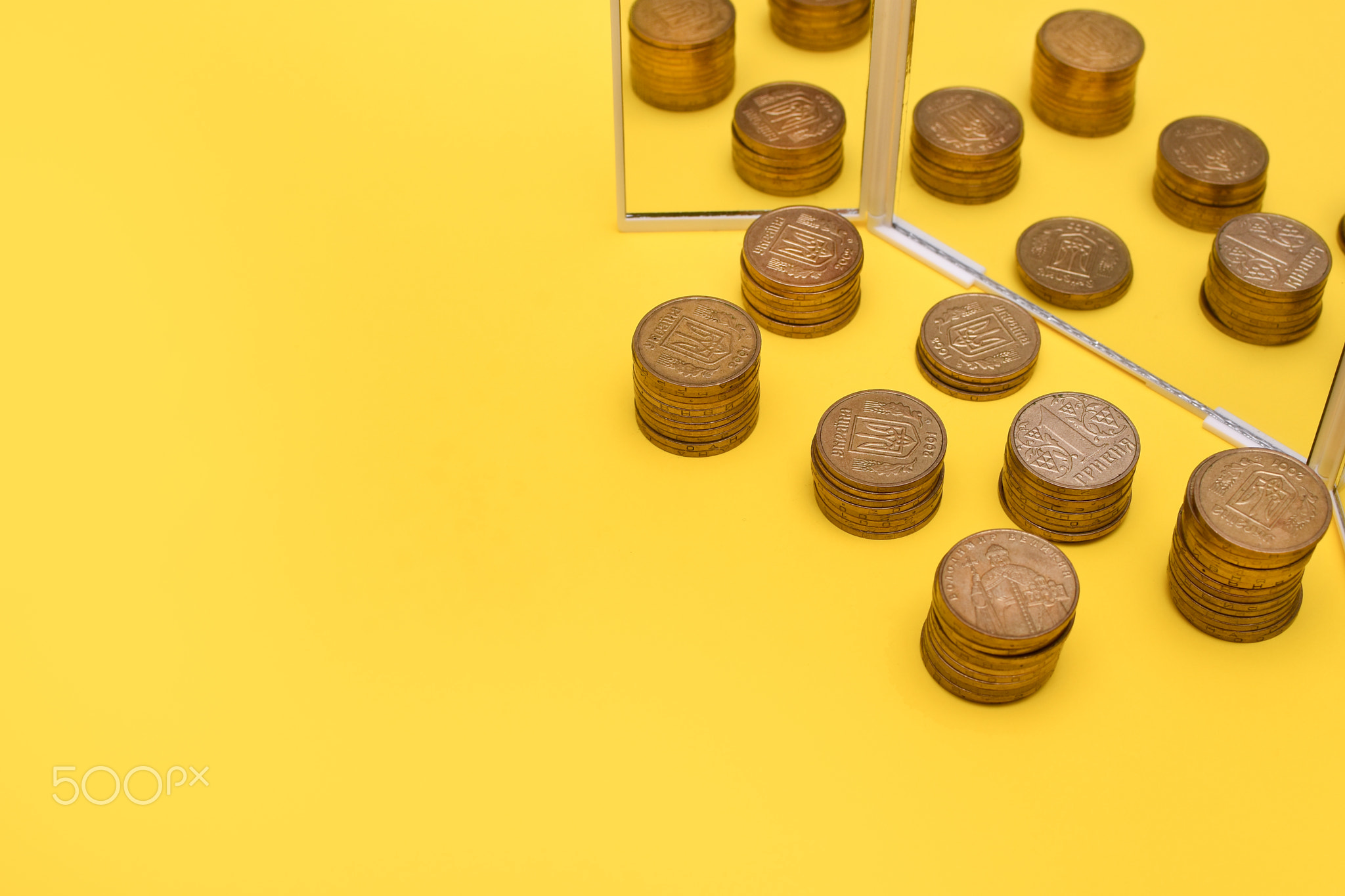 stack of coins near the mirror on a yellow background. mock up