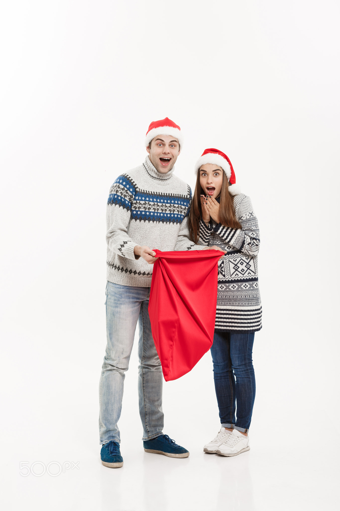 Christmas Concept - Full length Young attractive couple holding santa