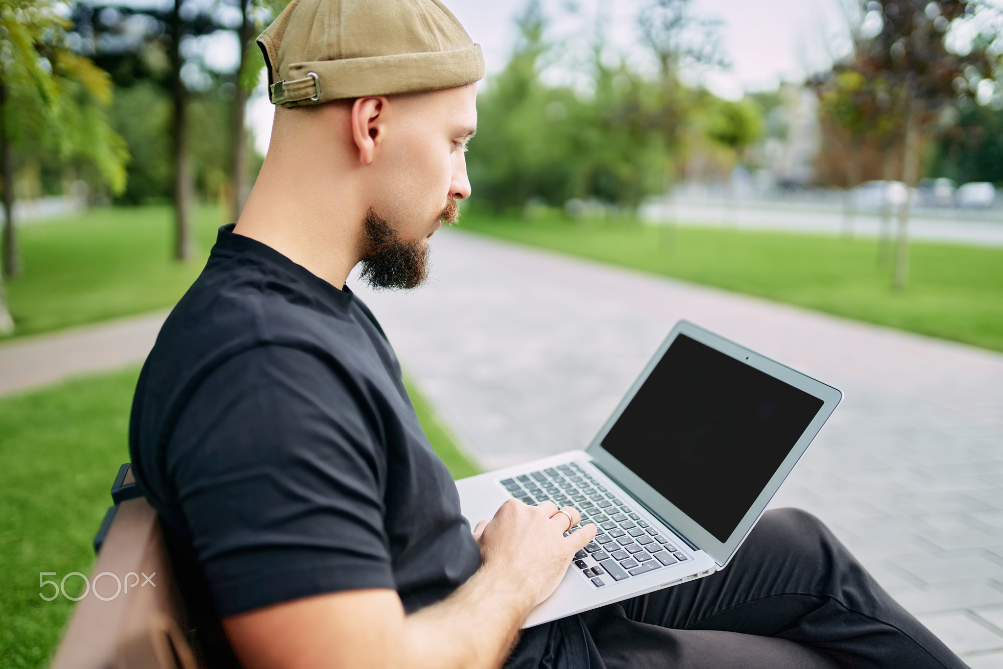 Man sits on the bench working, uses laptop with graphics, charts