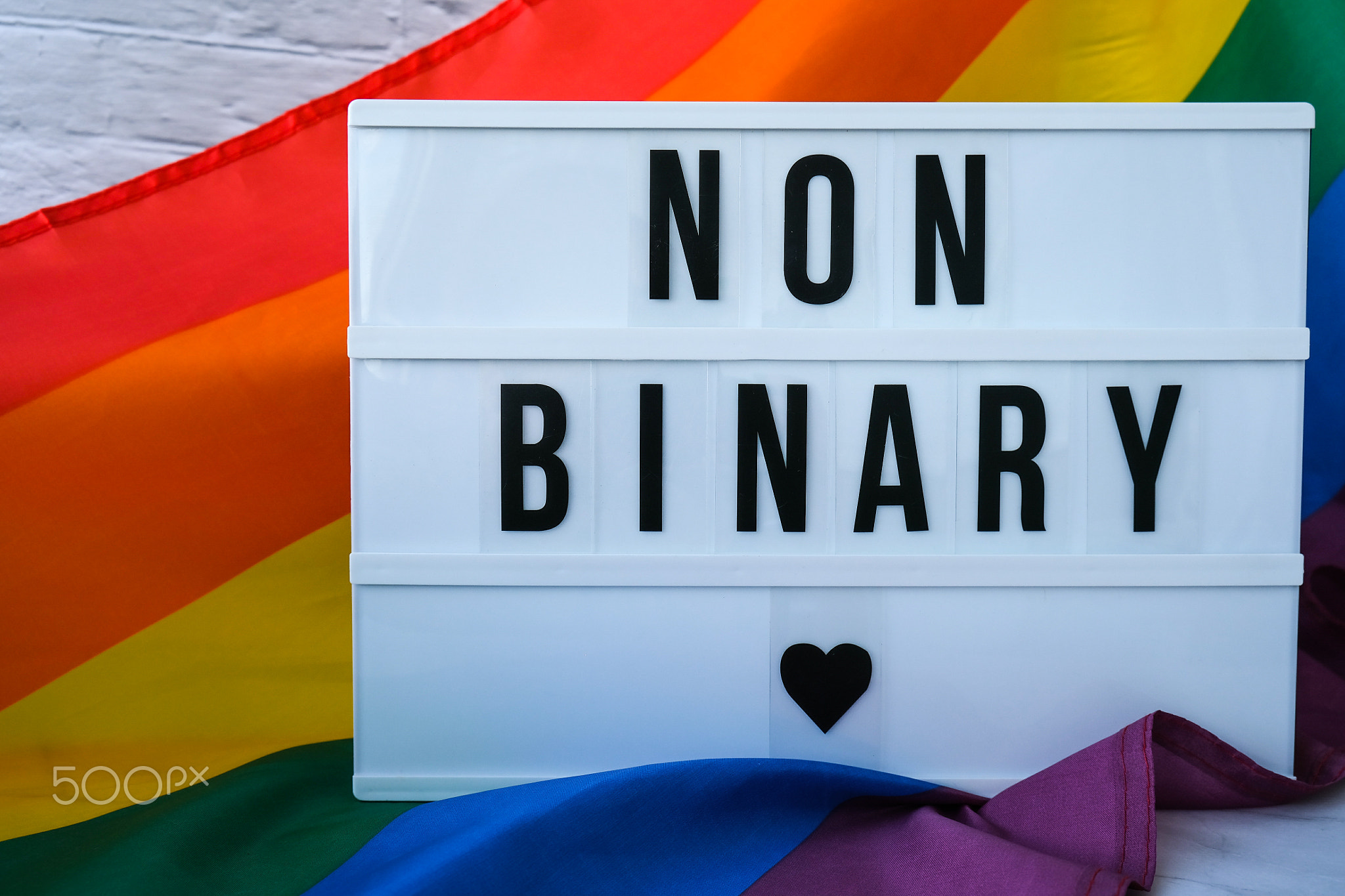 Rainbow flag with lightbox and text NON BINARY. Rainbow lgbtq flag