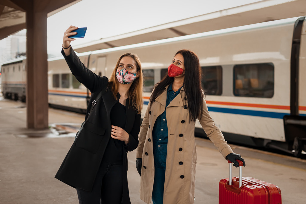 Female friends with face mask taking selfie with mobile phone by Haris Mulaosmanovic on 500px.com