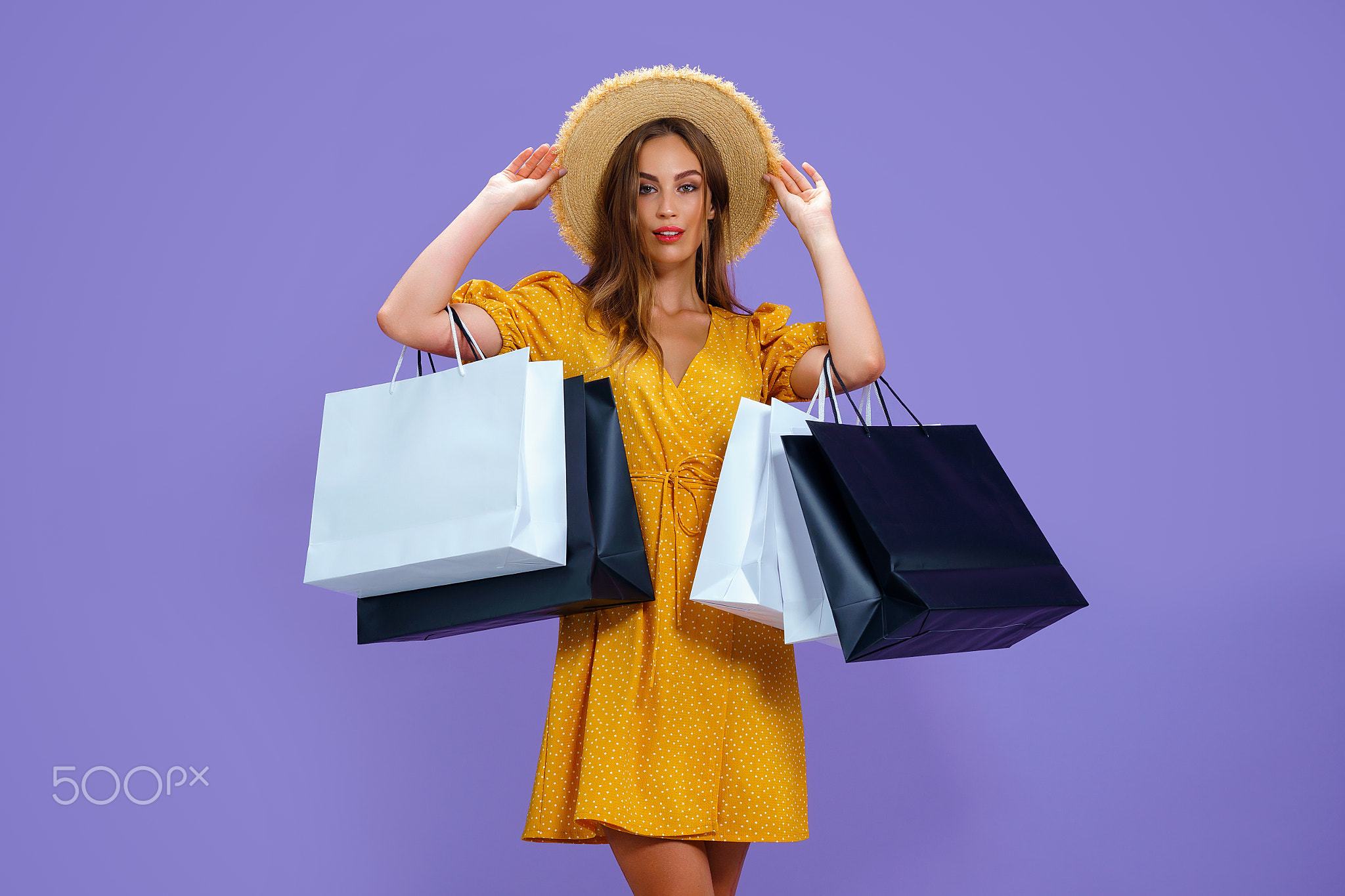 Fashion adult girl holds shopping bags on purple background. sale